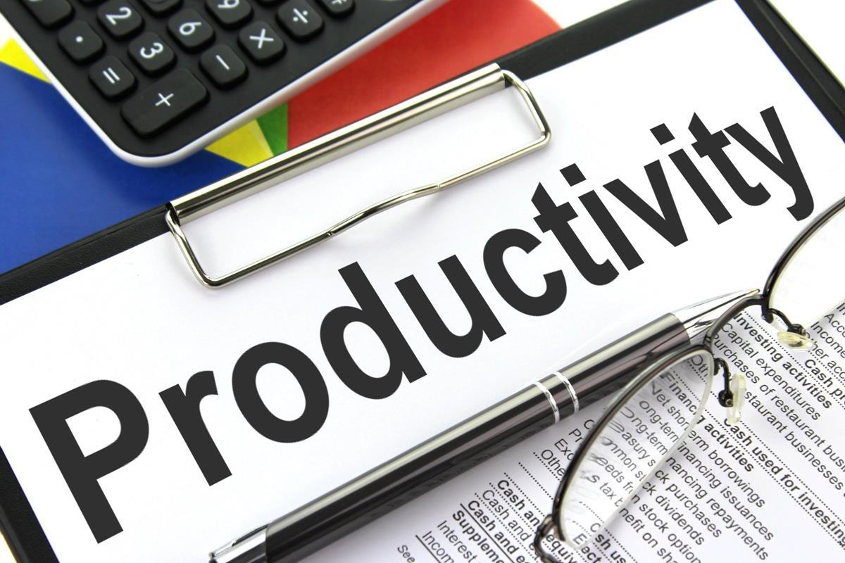 A sign with productivity written on it, with a calculator, a pair of glasses and financial documents next to it.