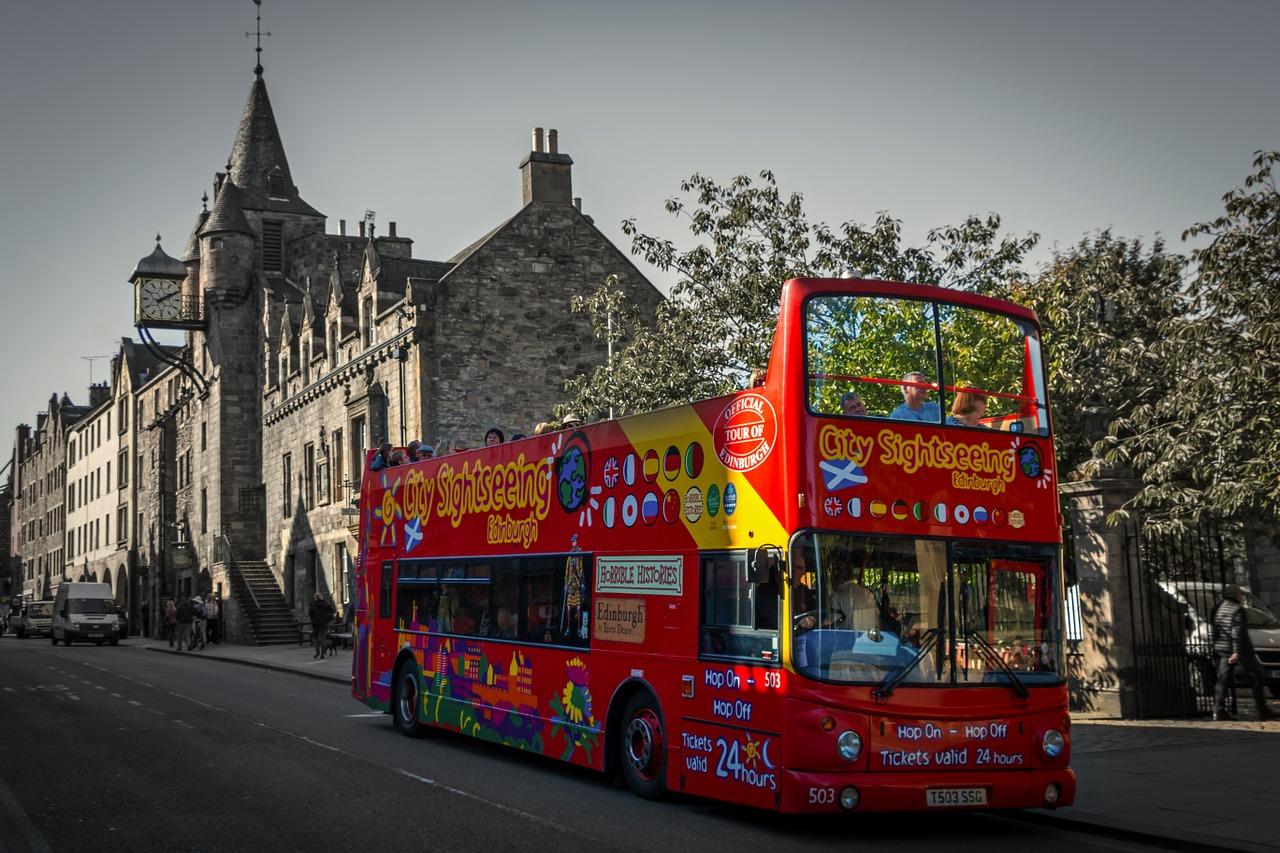 A red tour bus driving through Edinburgh