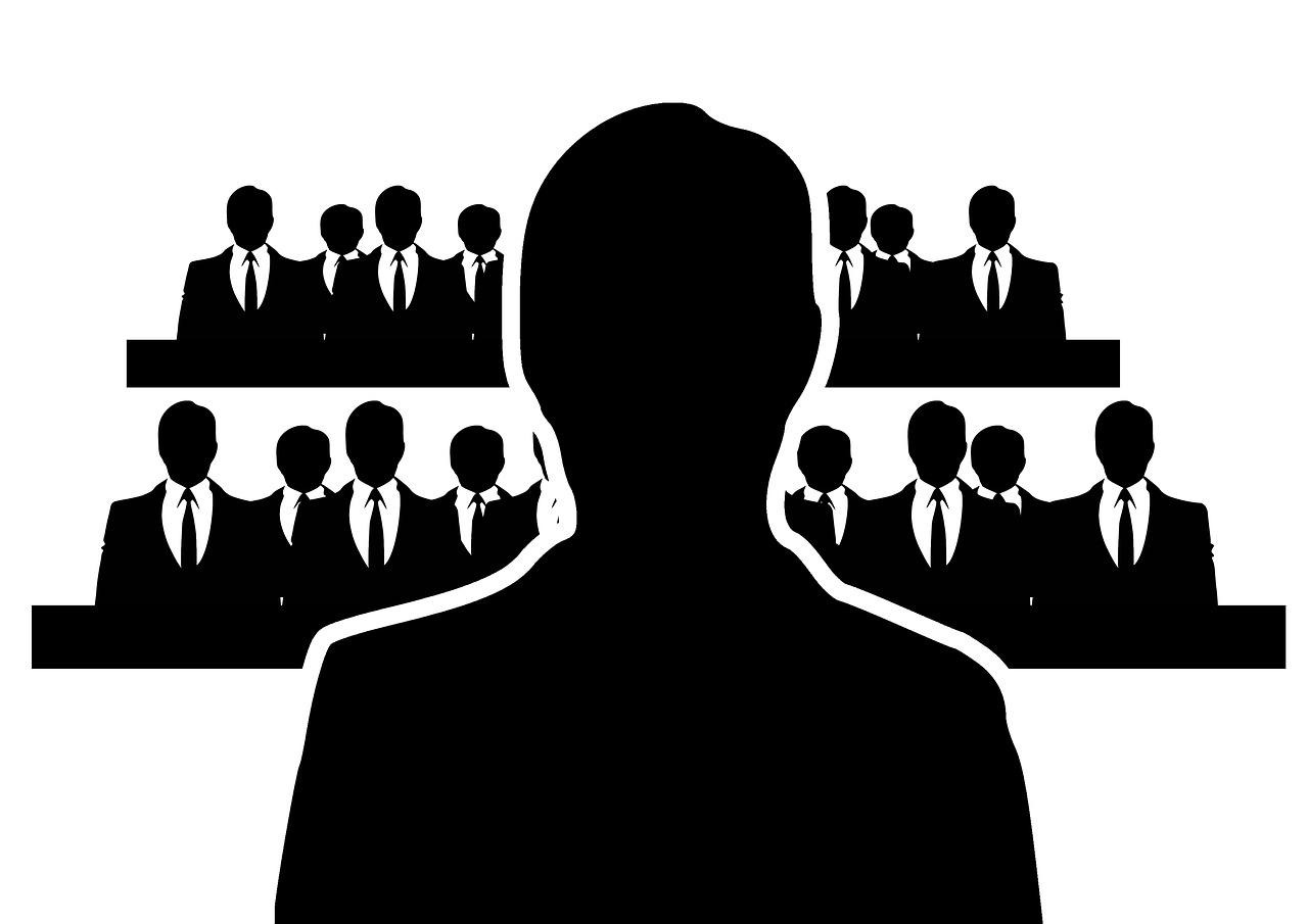 A silhouette of a man's top half in front of a crowd of people in suits. Finding an online Portuguese tutor doesn't have to be difficult.