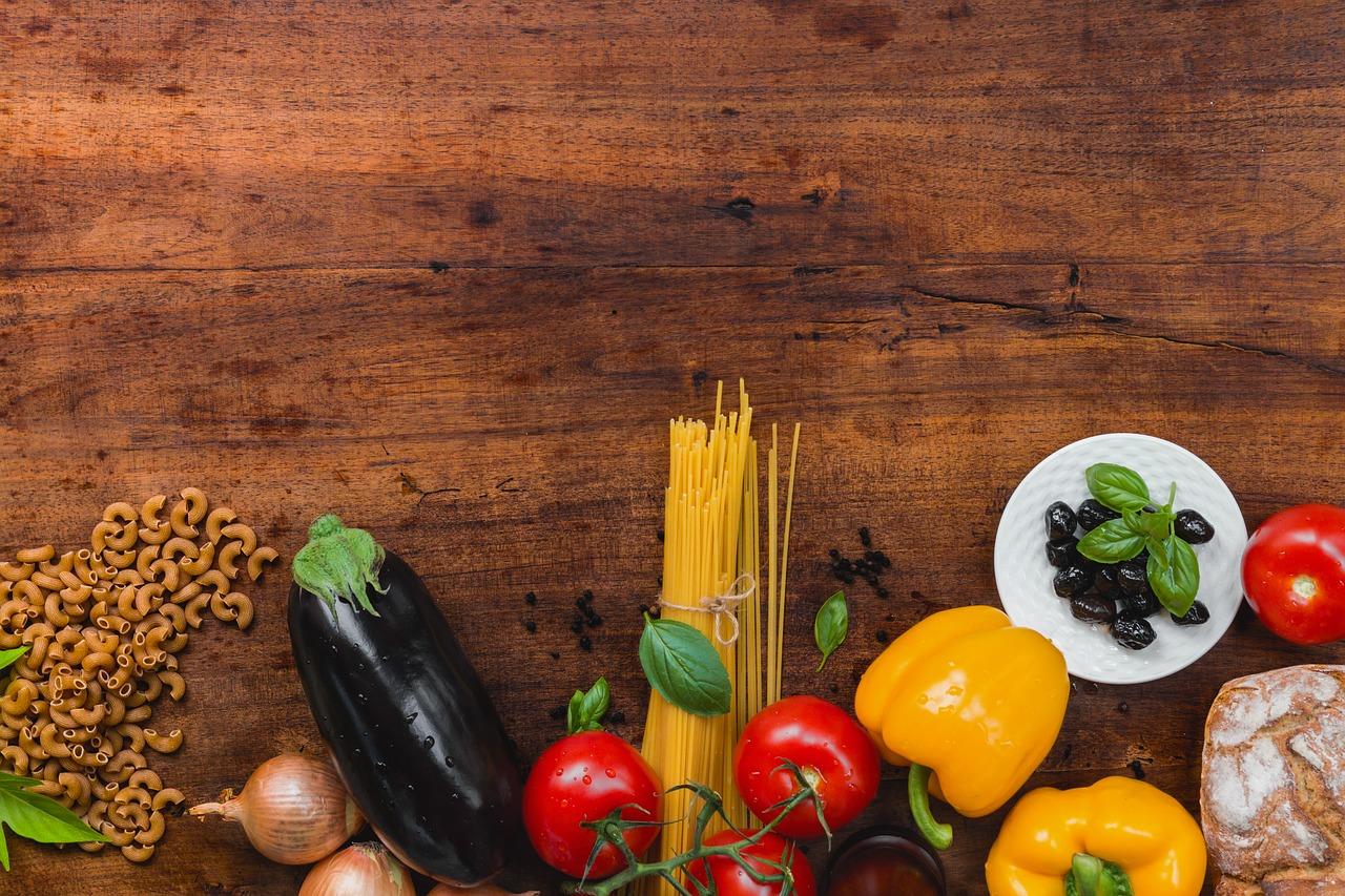A variety of different foods, including pasta, peppers, aubergine, bread, onion and olives. These foods can be part of a healthy diet.