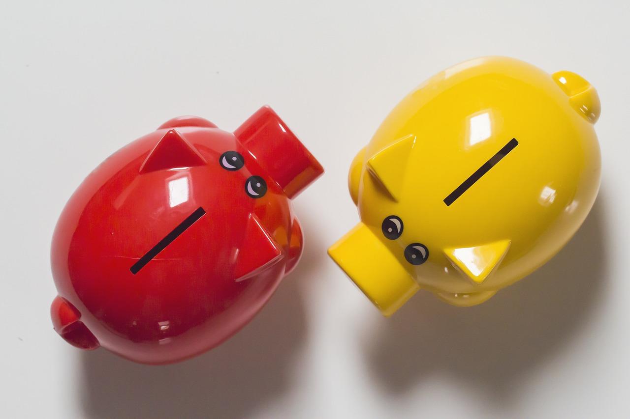 An image of a red piggy bank and a yellow piggy bank. Knowing your budget for Portuguese lessons can be helpful.