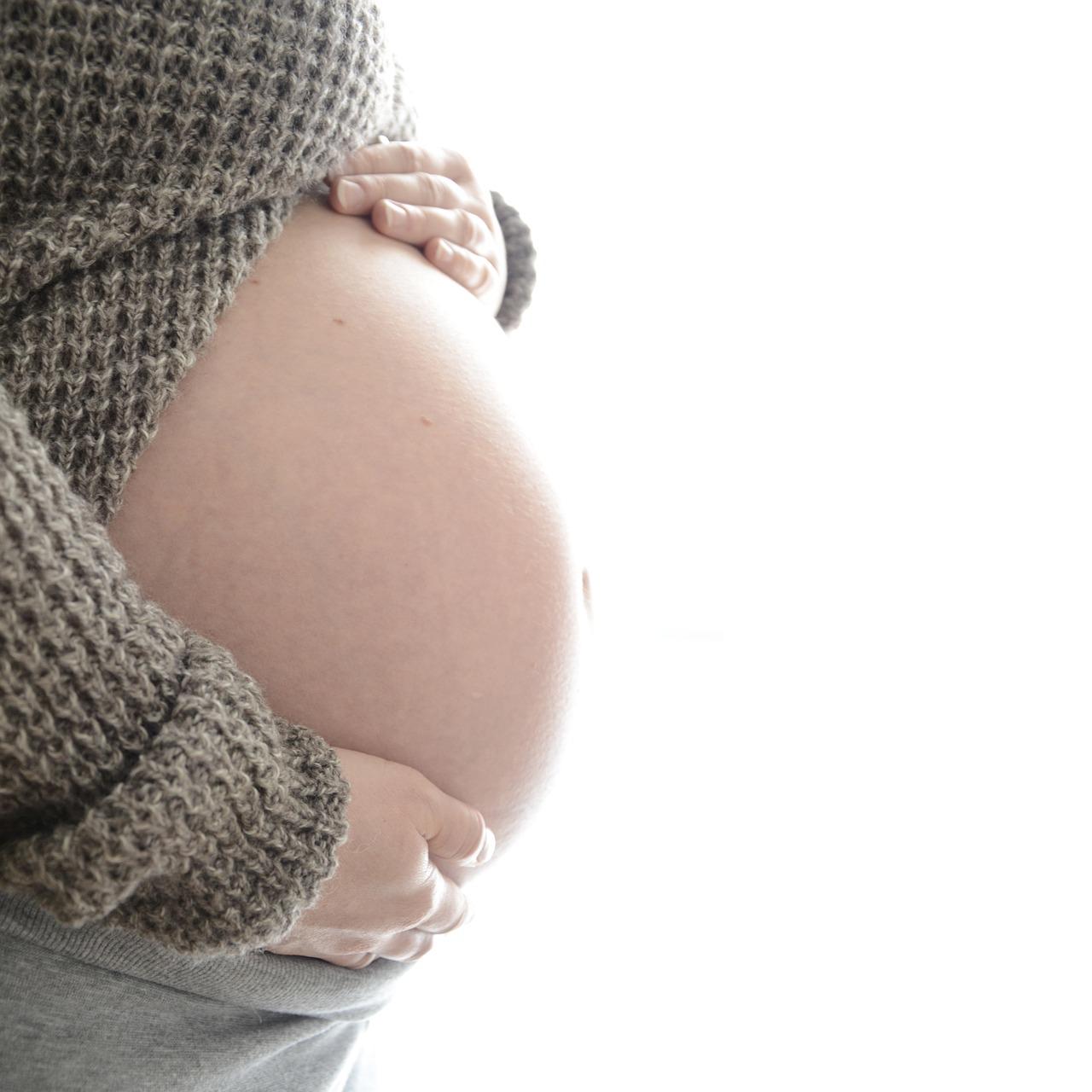 A pregnant woman holding her pregnant belly. Good pregnancy nutrition is really important.