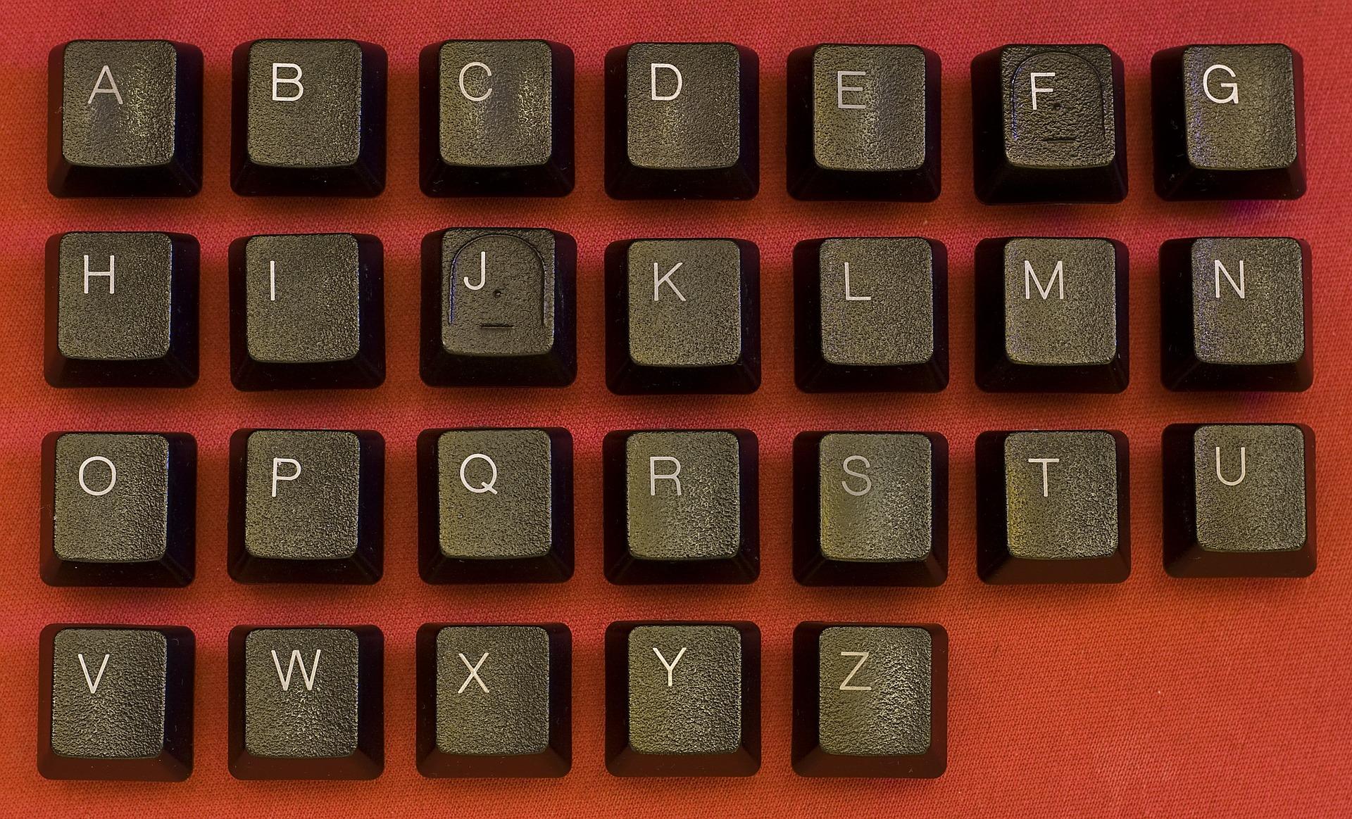 An image of letters on a keyboard on top of a red background. There are 26 letters in the Portuguese alphabet.