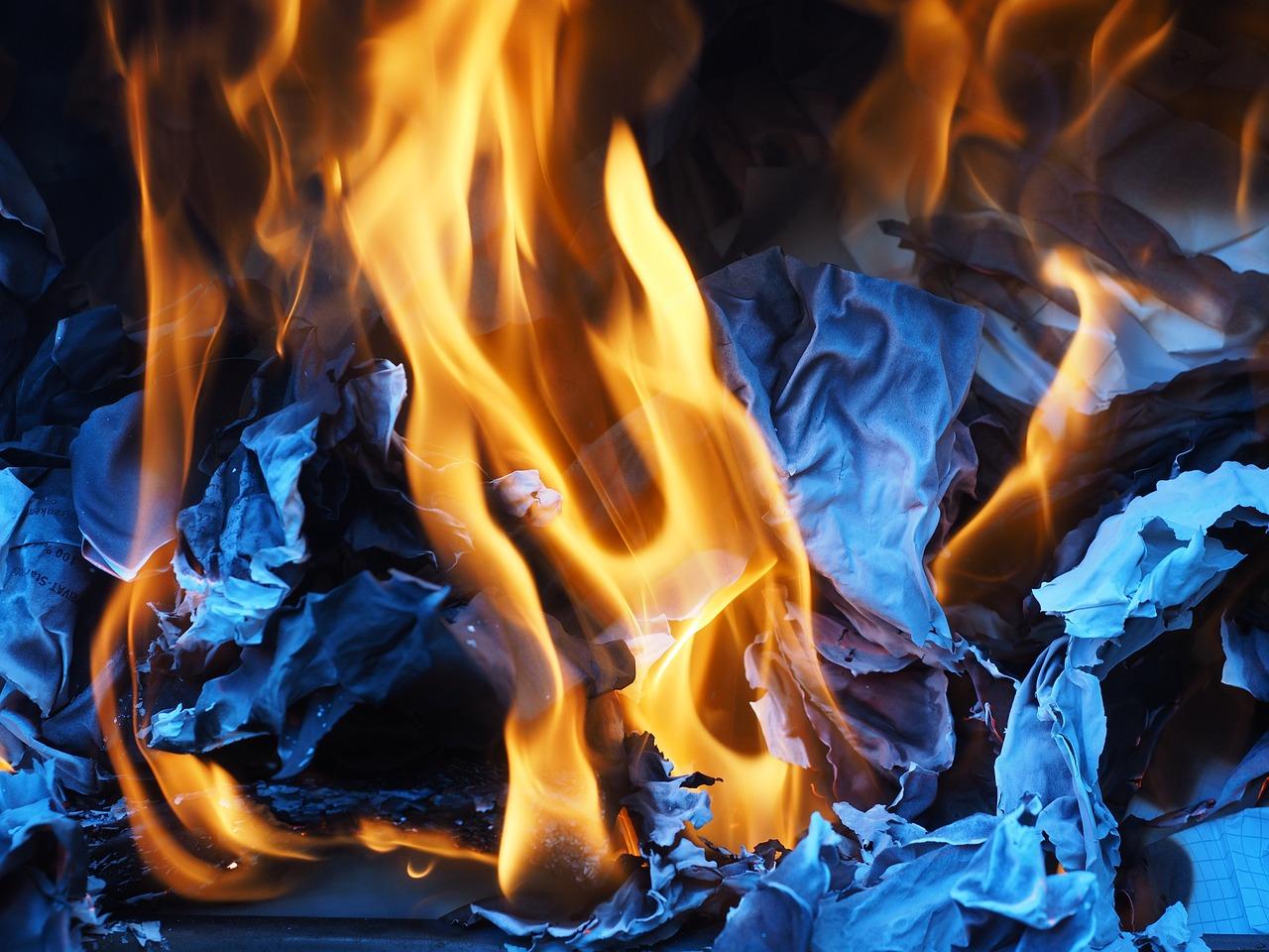 A yellow flame burning blue paper. Combustion is something that you might be taught about in a chemistry GCSE.