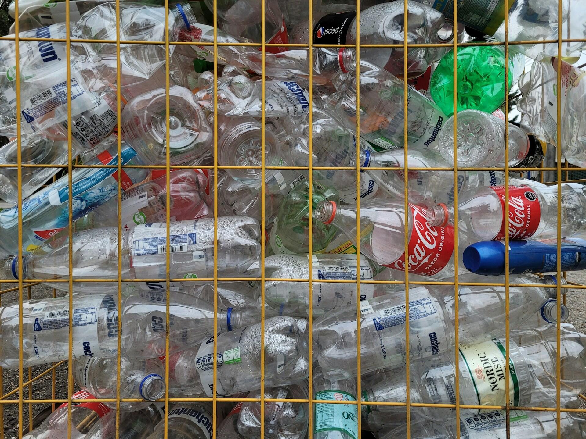 A wire container filled with used plastic bottles.