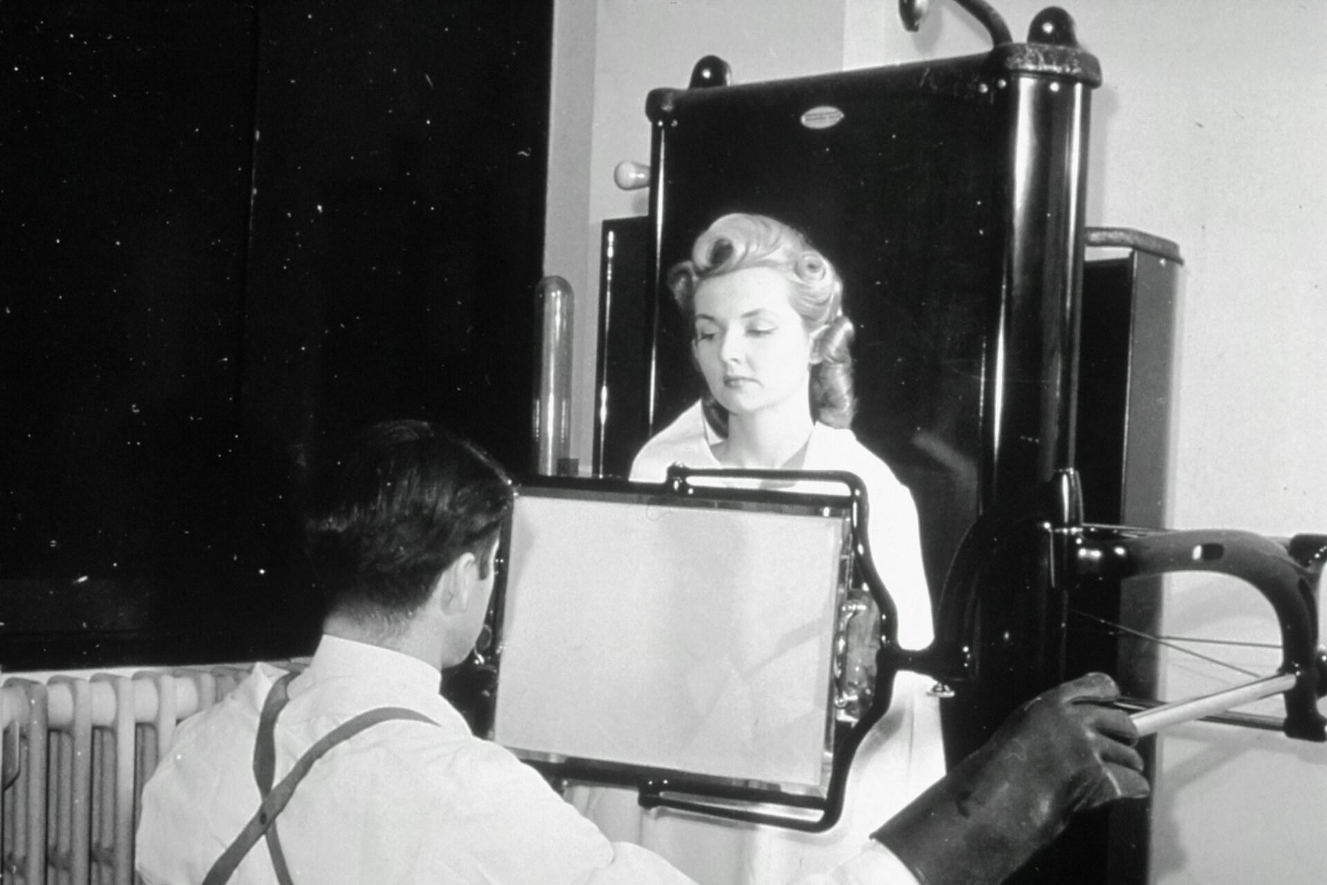 A patient submits to an xray from a technician.