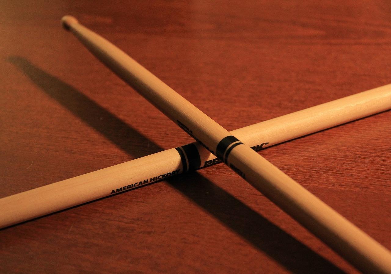An image of drumsticks, with one placed over the other to form a cross. You can still learn to play the drums with just drumsticks.