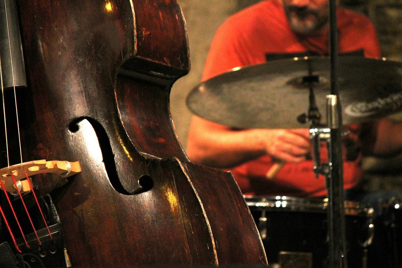 A drummer drumming in front of a double bass. Learning to play jazz drums can be very rewarding.