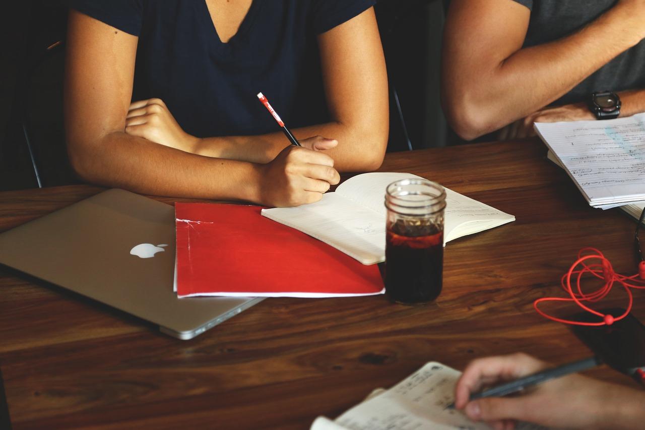 An image of two people revising, with notepads and an Apple Mac in front of one of the people. Drama lessons can help you get better at acting.