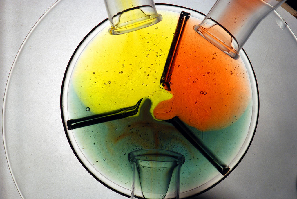 orange, yellow and green liquids in a chemistry beaker