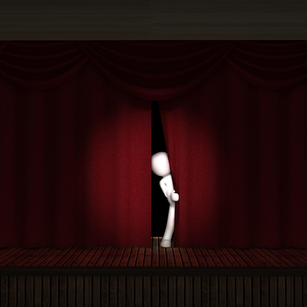 A 3D man standing partly behind a theatre curtain with the spotlight on him