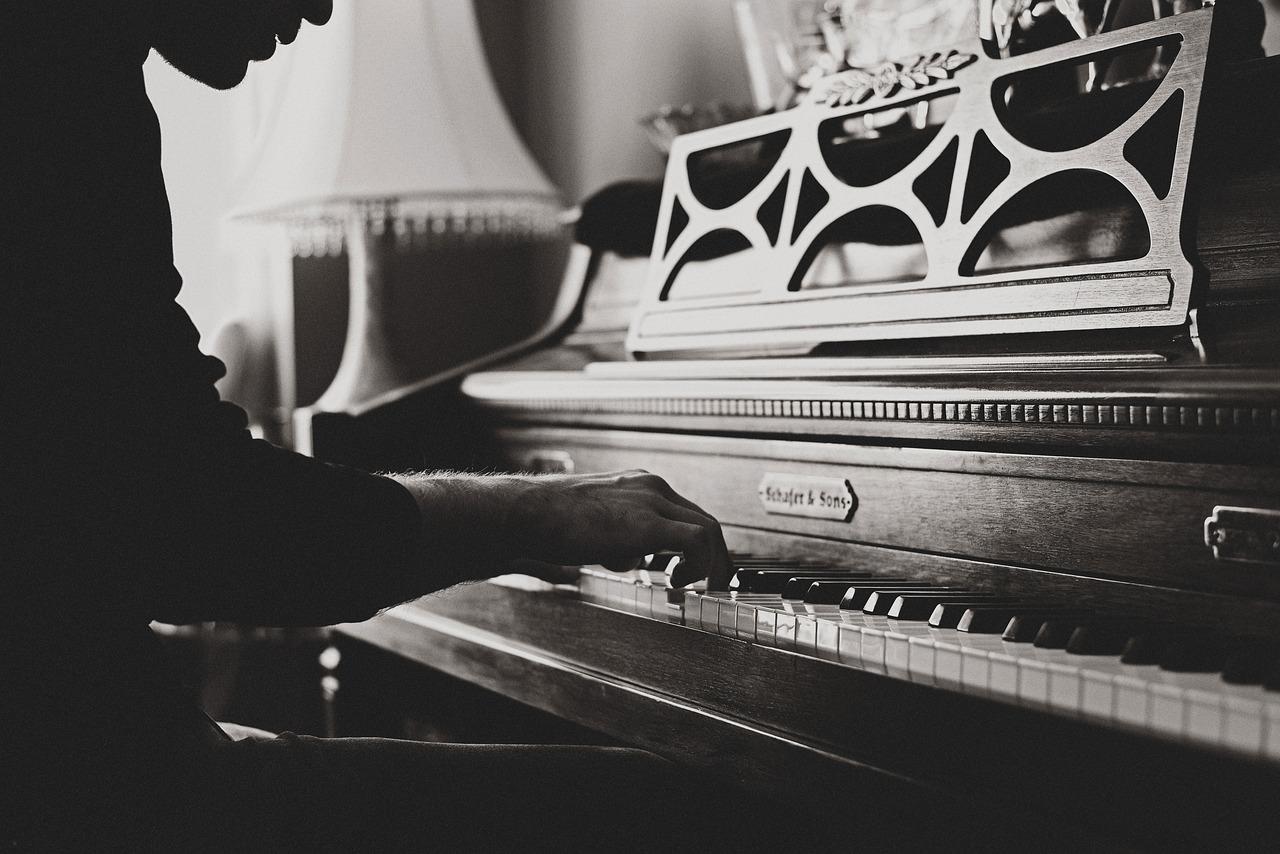 A black and white image of a man playing the piano