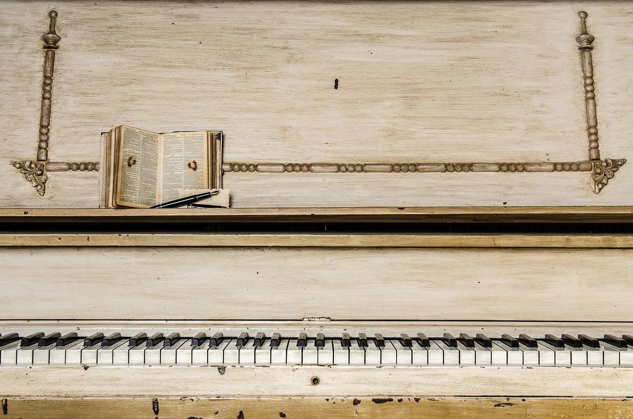 A piano with a book and pen on top of it