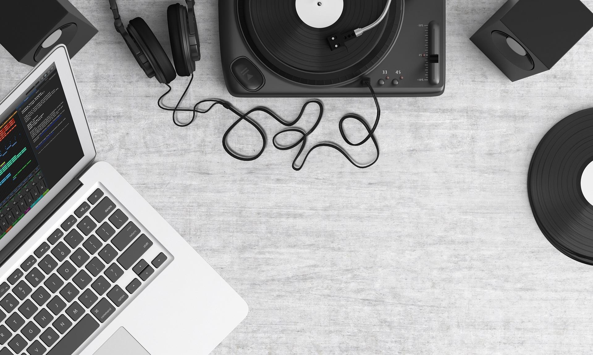 A top-down image of a laptop, turntable, and vinyl