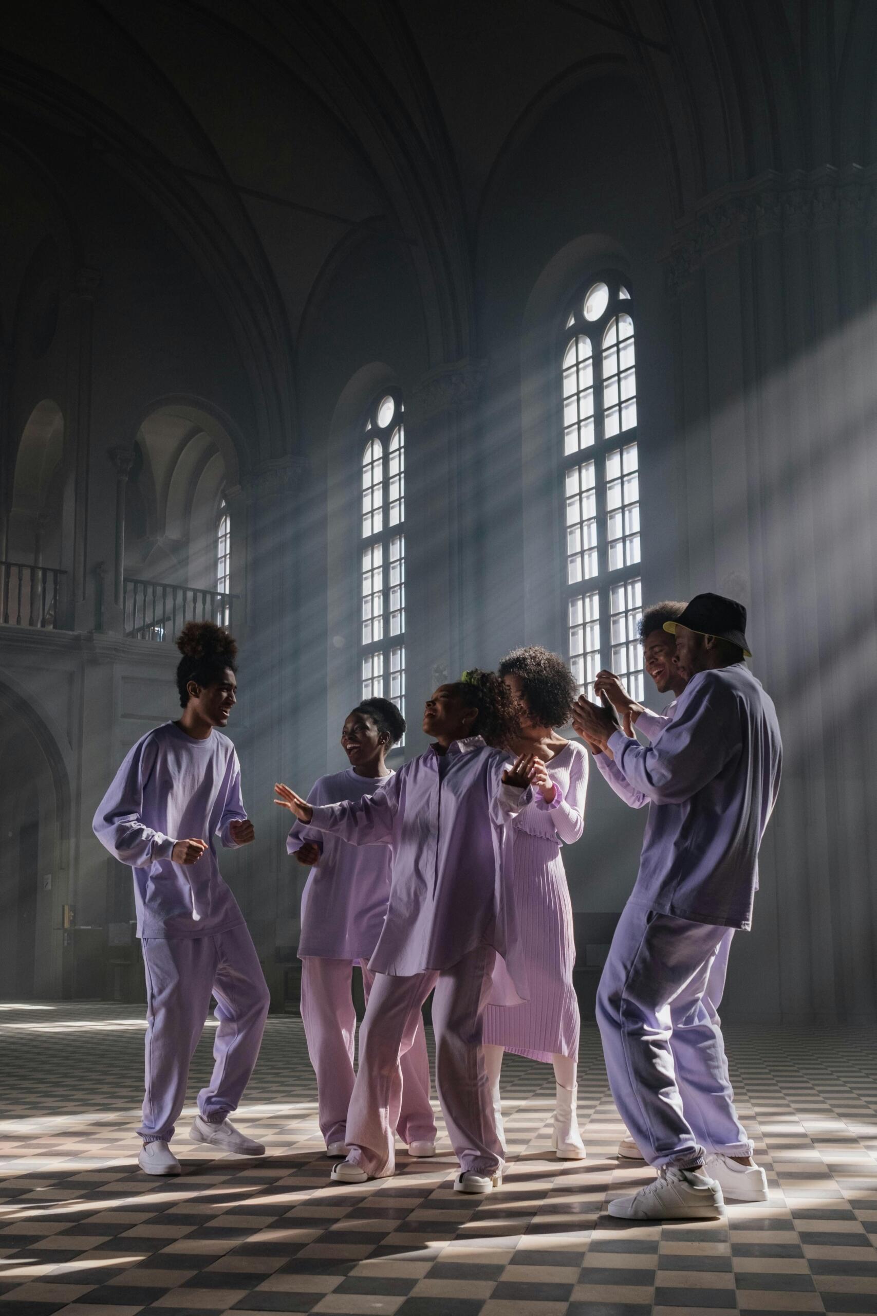 Group of people in lilac uniforms performing music together.