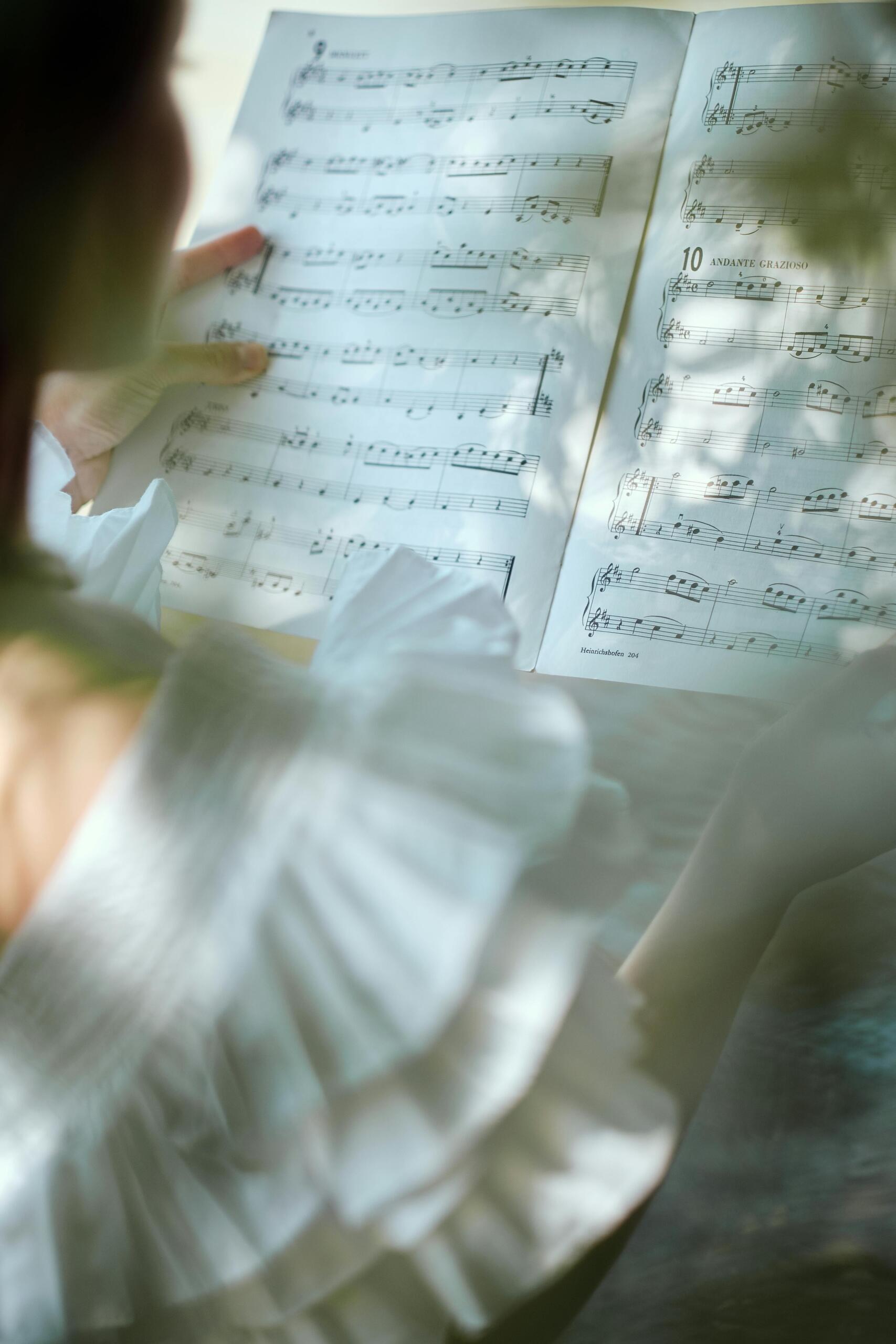 Person holding a musical composition sheet.