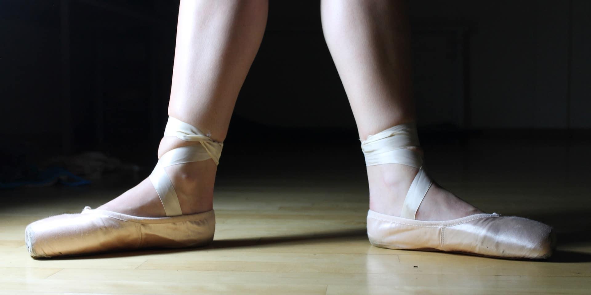 Two feet wearing ballet shoes standing in the initial pose. Some professional dance classes for kids will provide each student with all the equipment they need; however, these classes are also more expensive