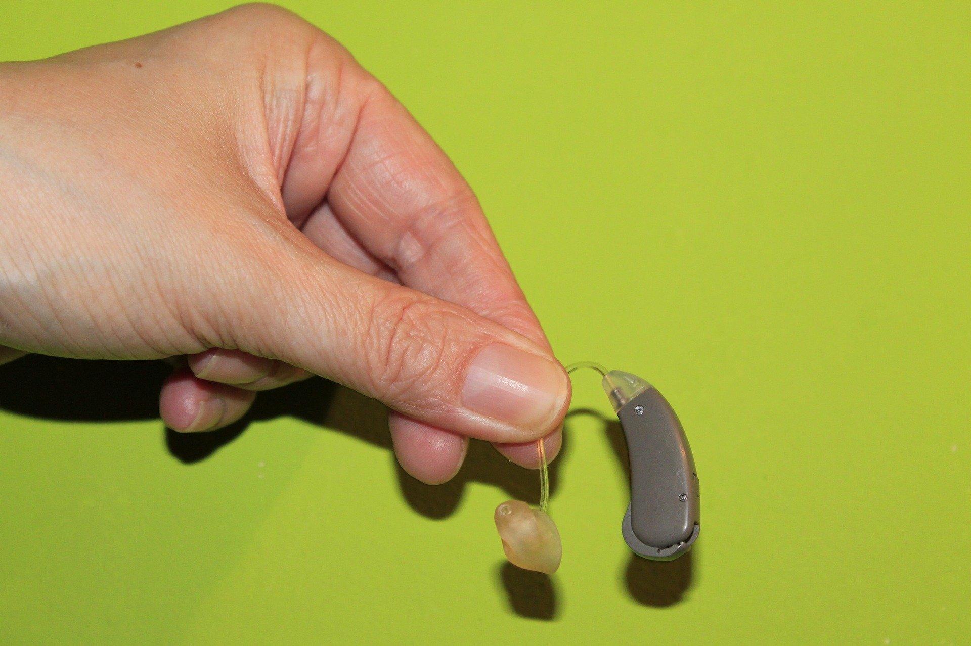 Your hearing impaired friend may turn off his hearing aid to force you to sign