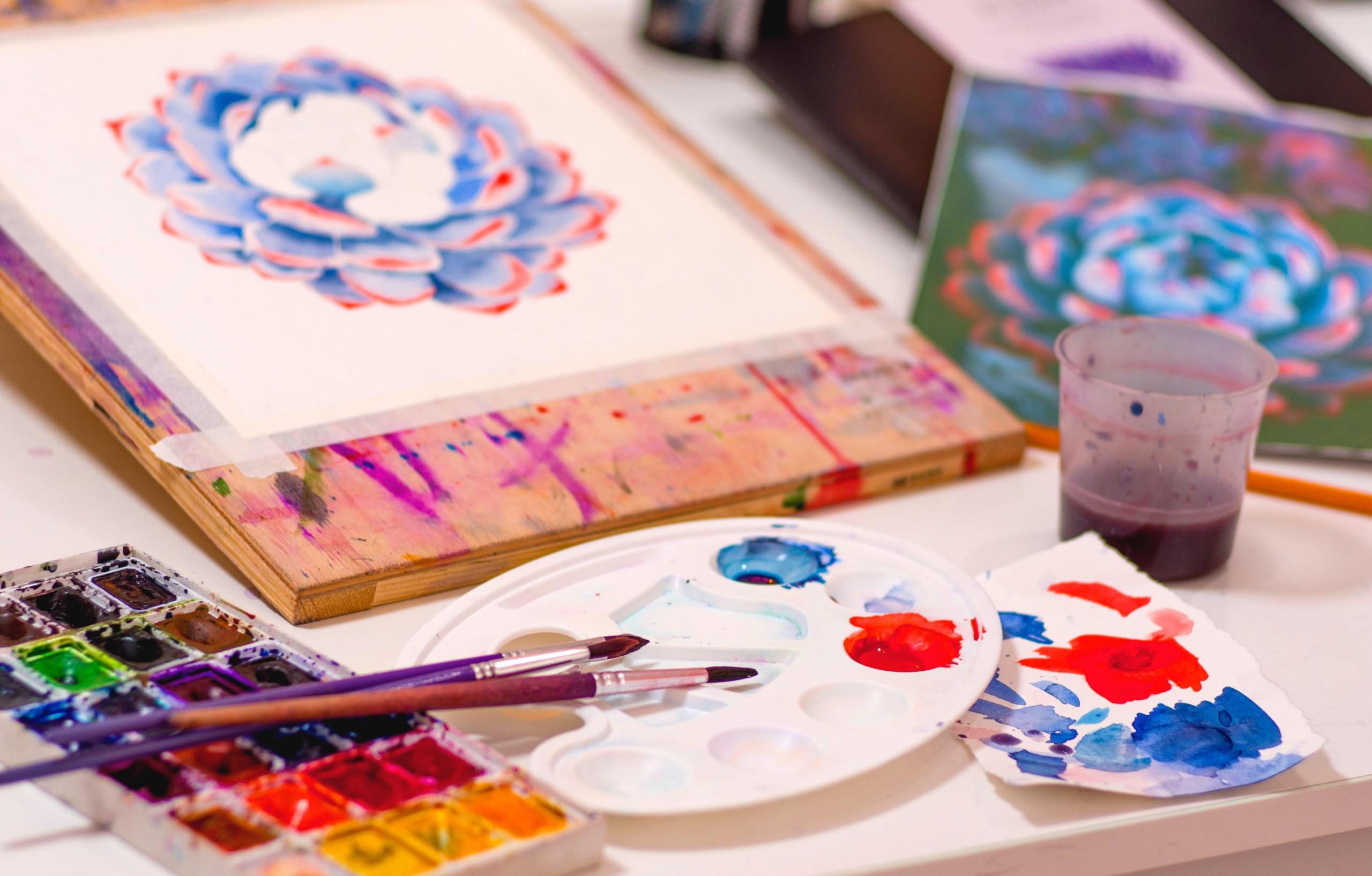 A paint palette and some floral artwork.