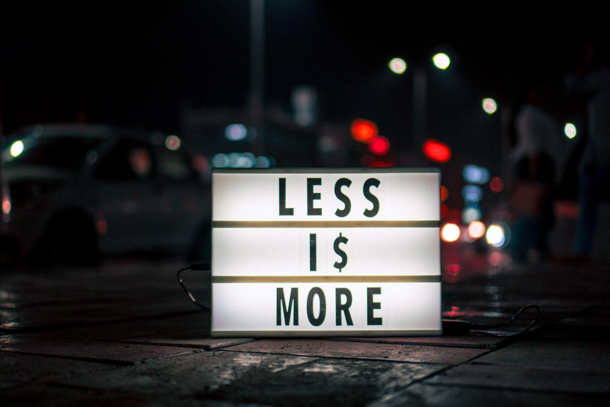Neon sign which reads ‘less is more’.