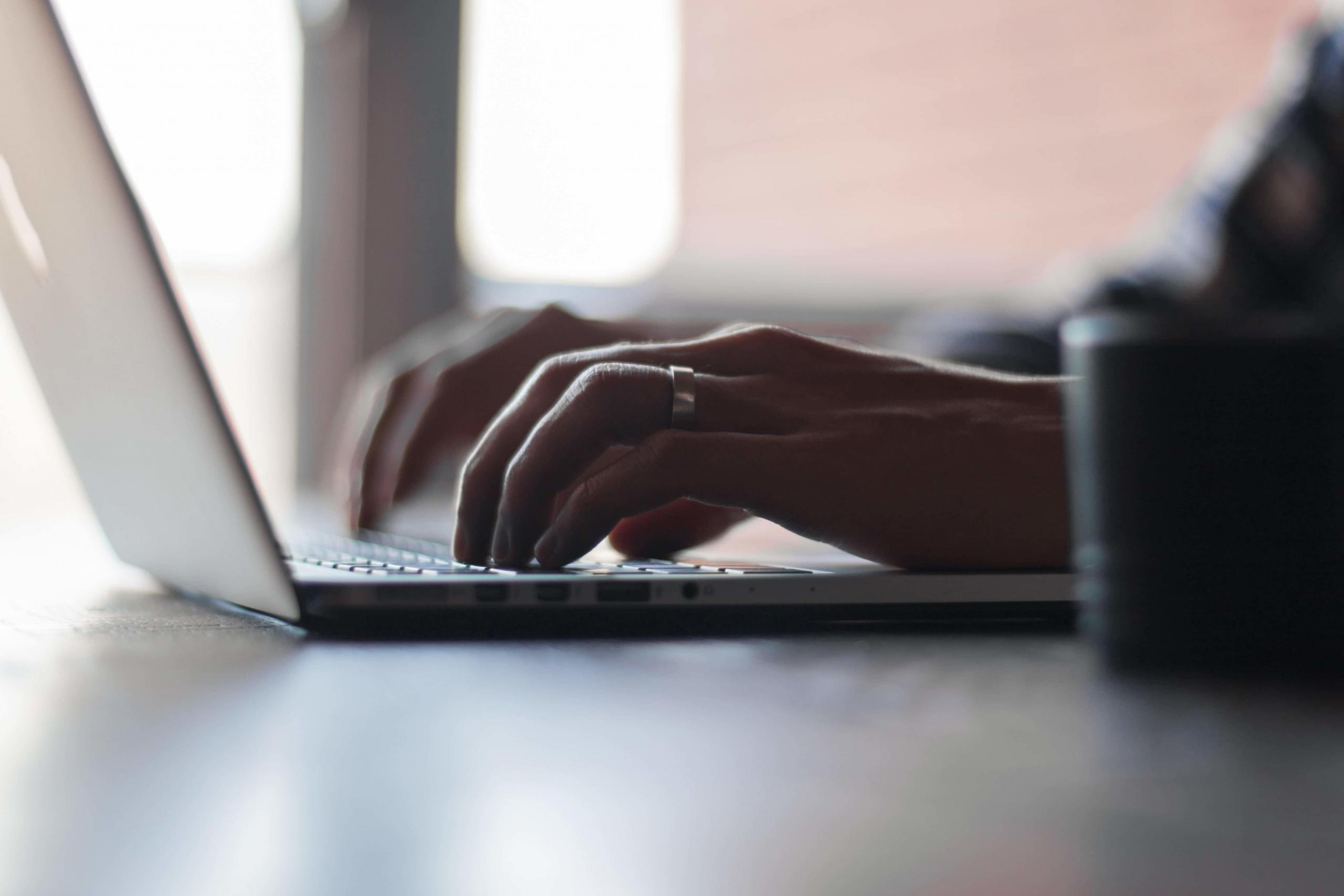 Man typing on a laptop.