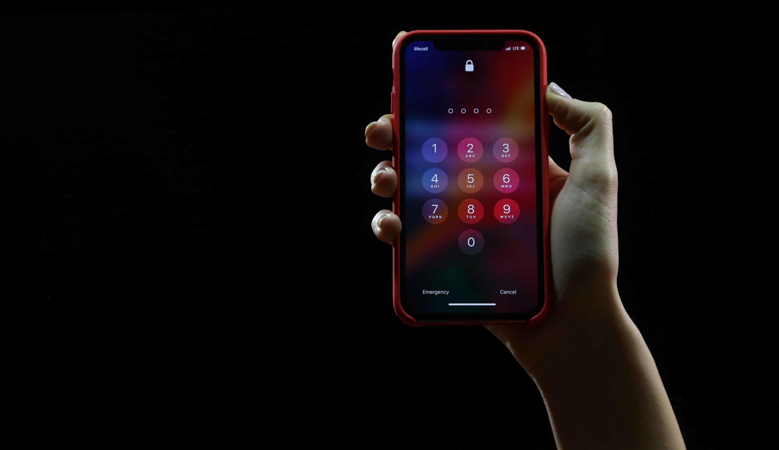 Person holding up their phone with passcode.
