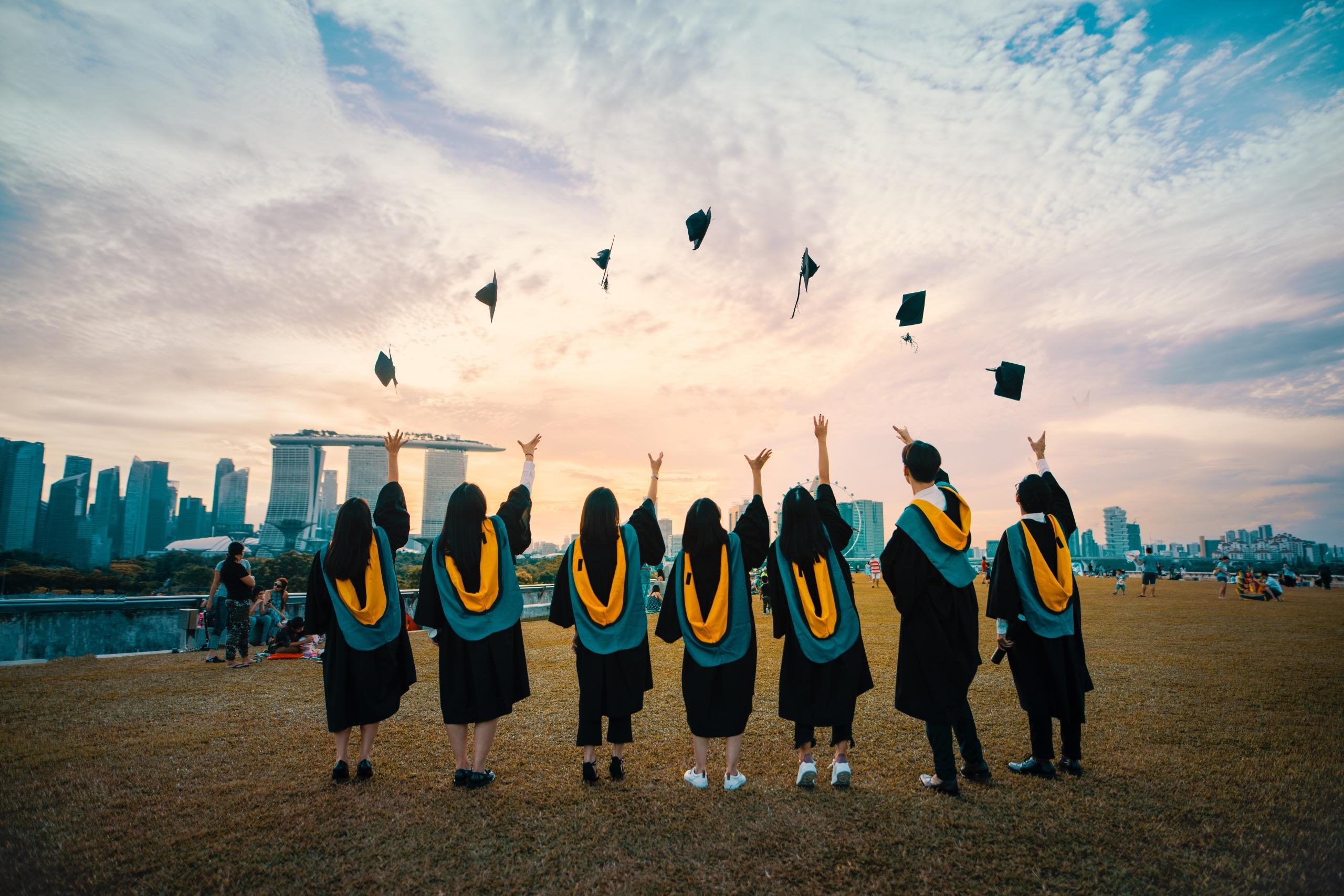 students on graduation day throwing their caps