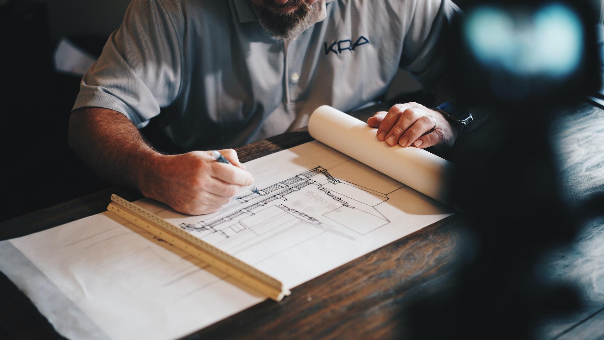 A Person drawing a structure plan by hand 