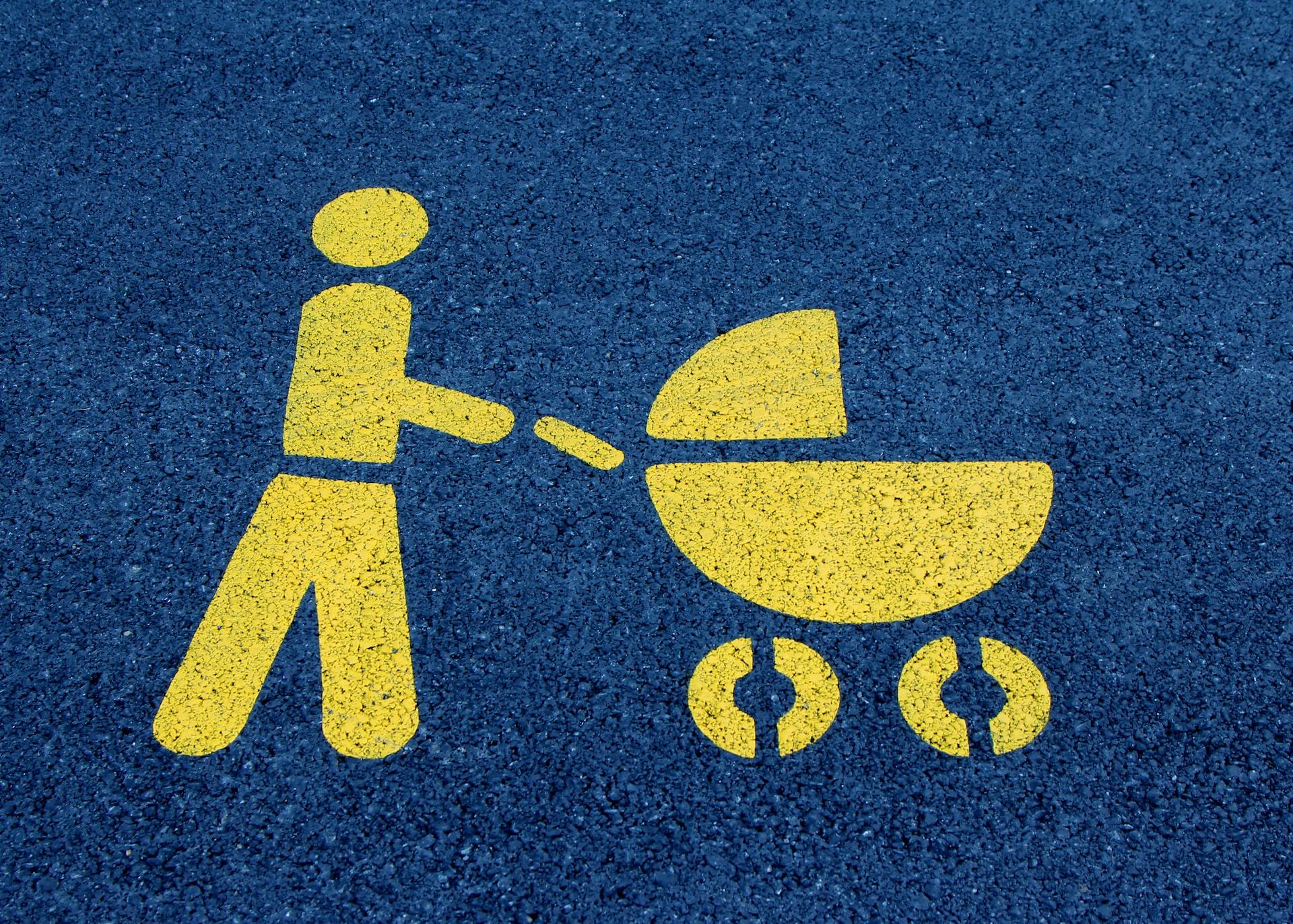 A blue and yellow parent and baby parking space sign