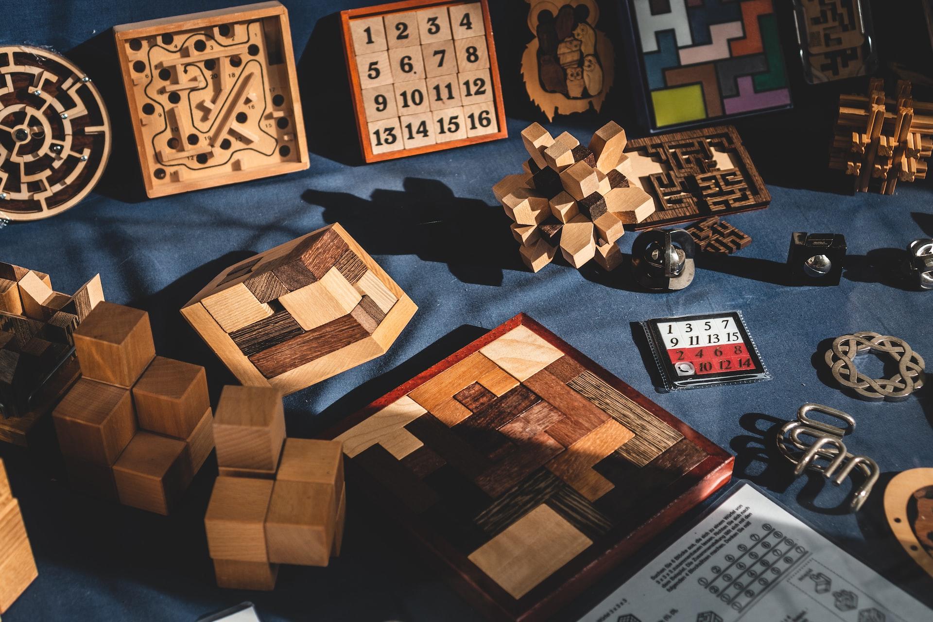 A variety of wooden puzzles laid out against a blue background.