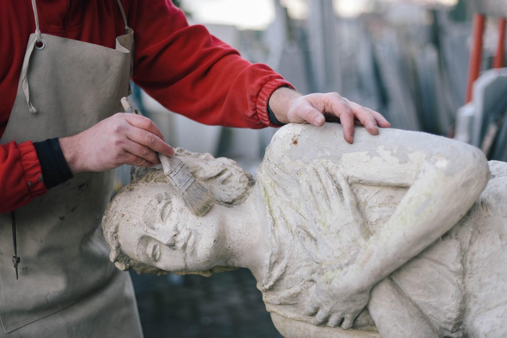 An old statue being cleaned by an art reservator.