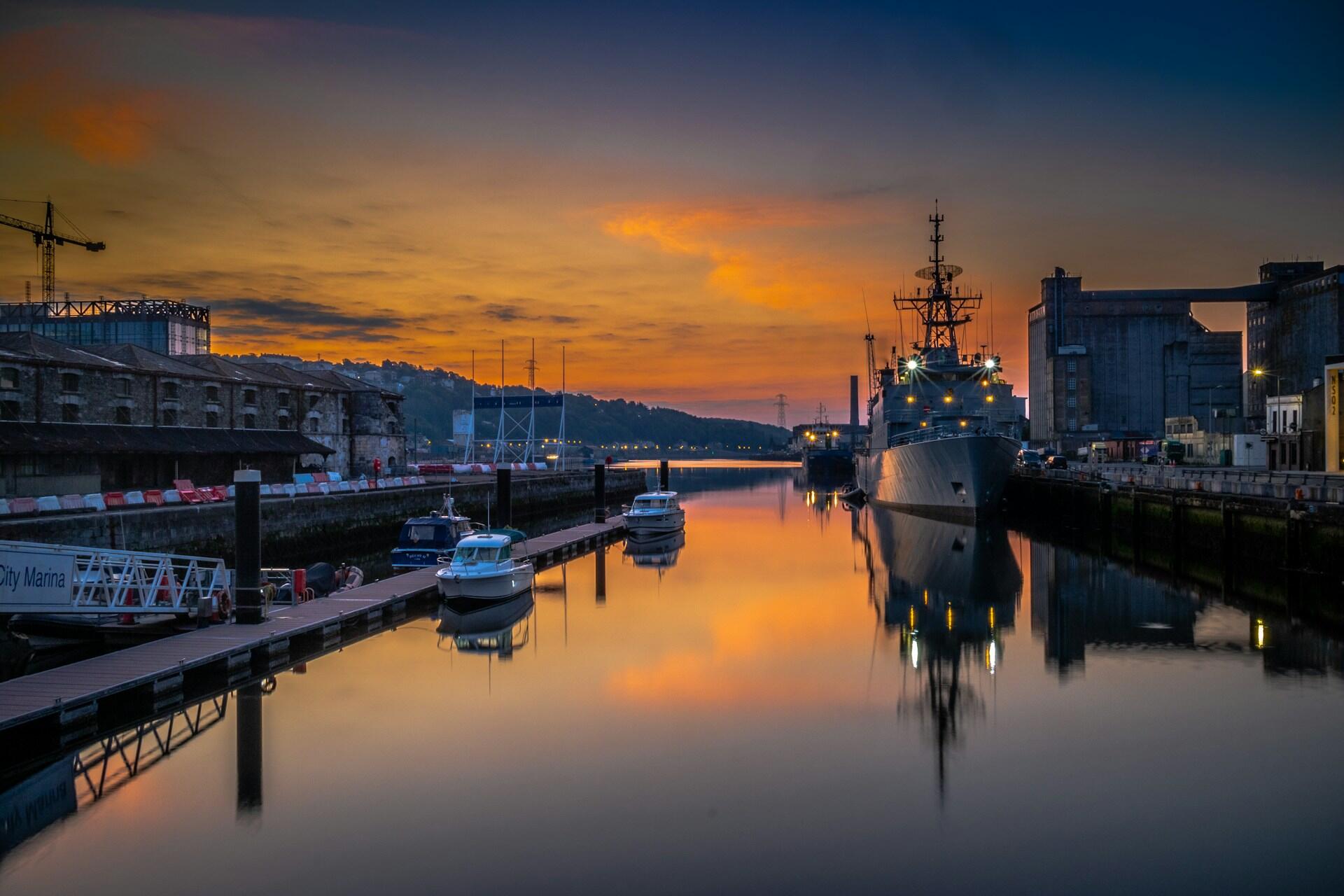 A harbour with a large boat at sunset.