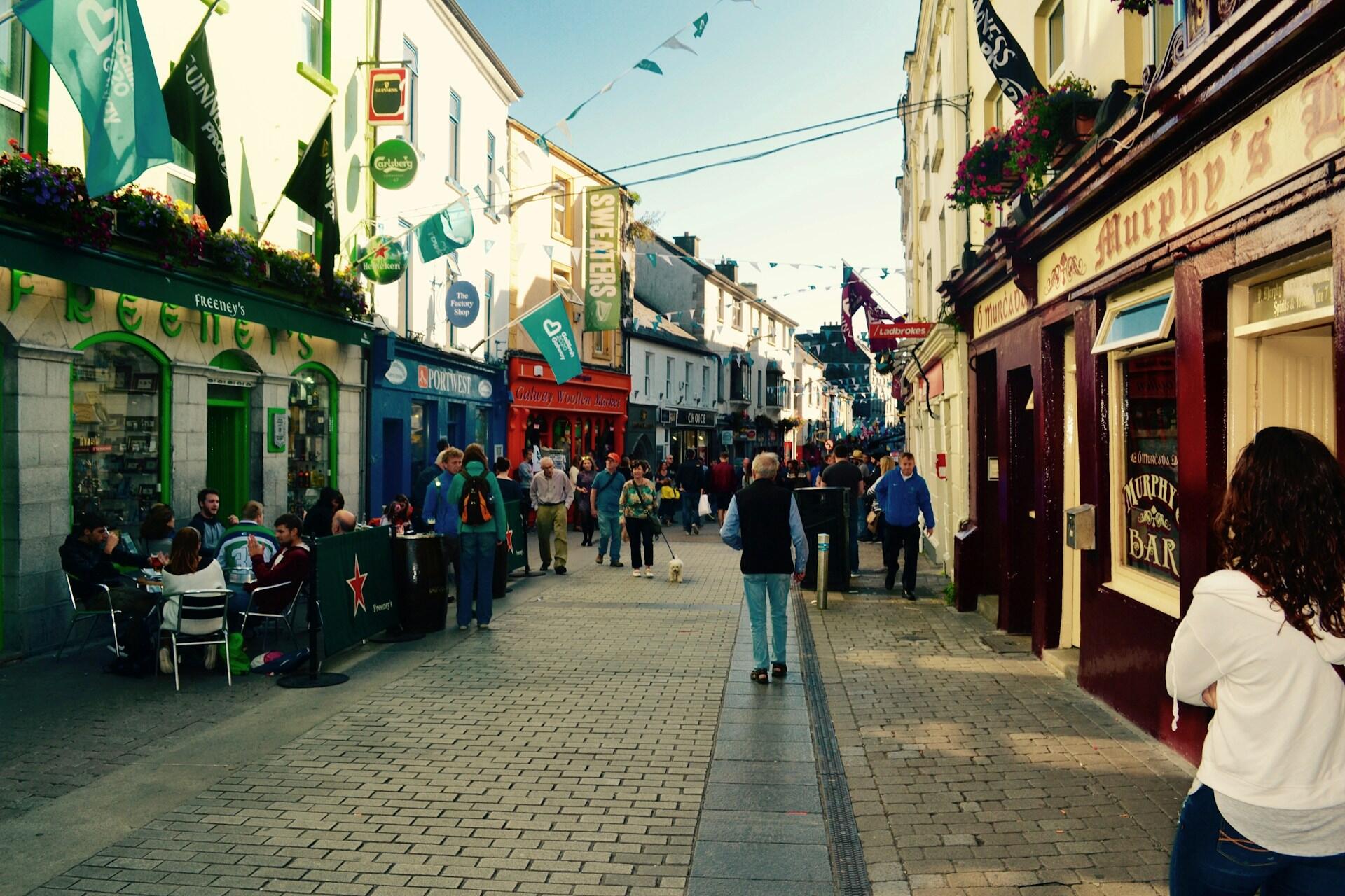 People enjoying a street scene on a sunny day.
