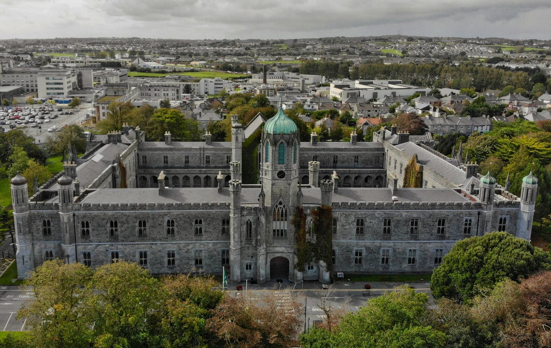 A large stone building with a twon behind it.