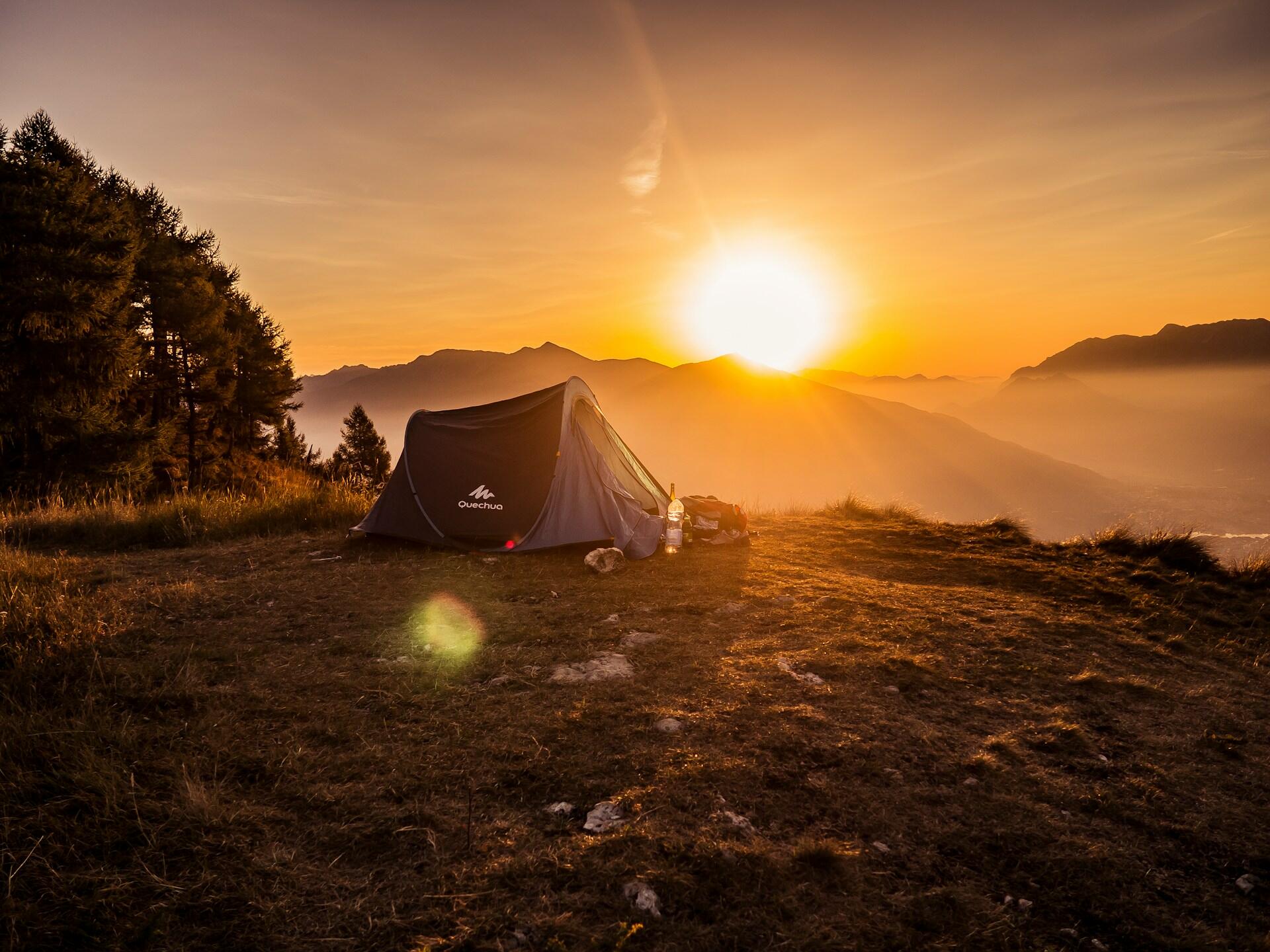 A tent on a plateau at sunset.