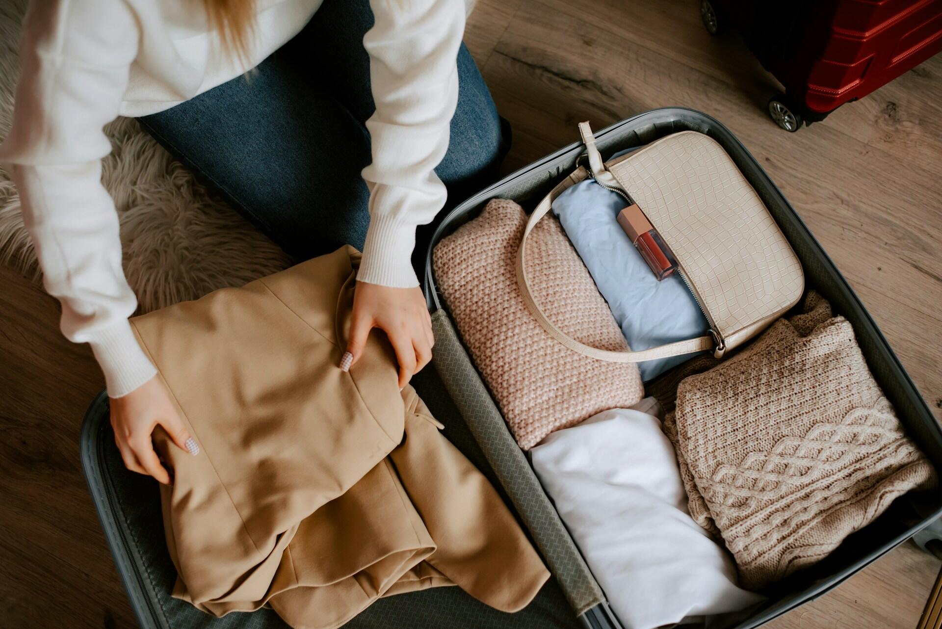 A person packing a suitcase