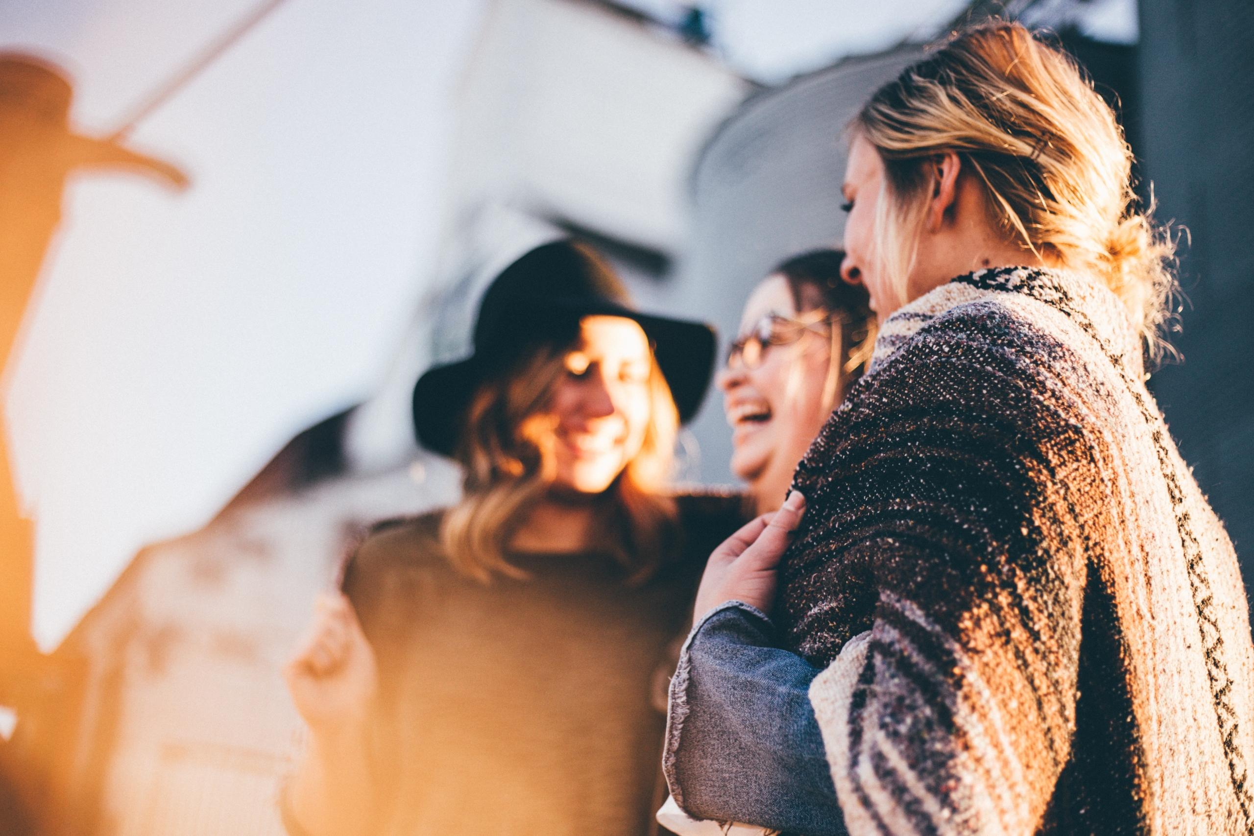 Three women standing together, laughing