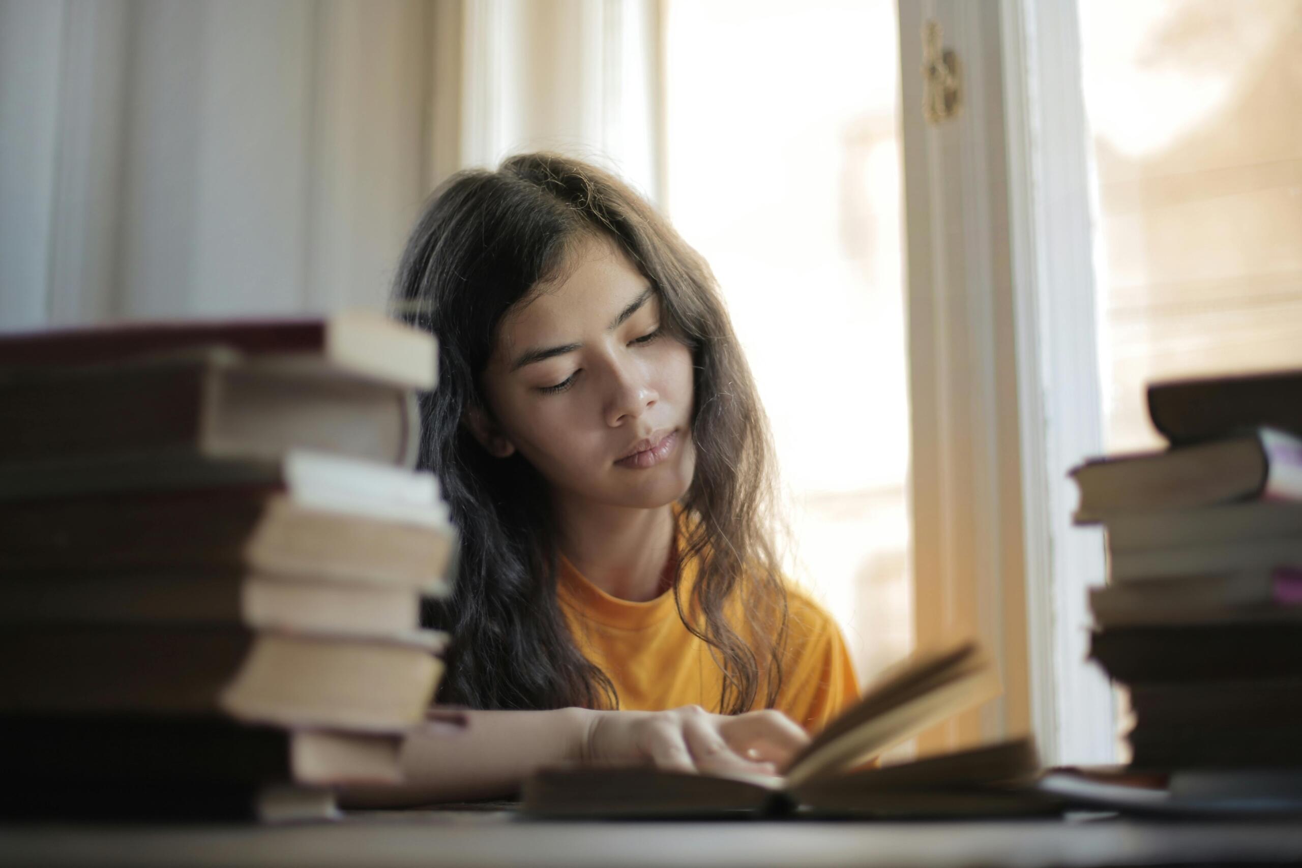 Clever lady with curly hair reading a book