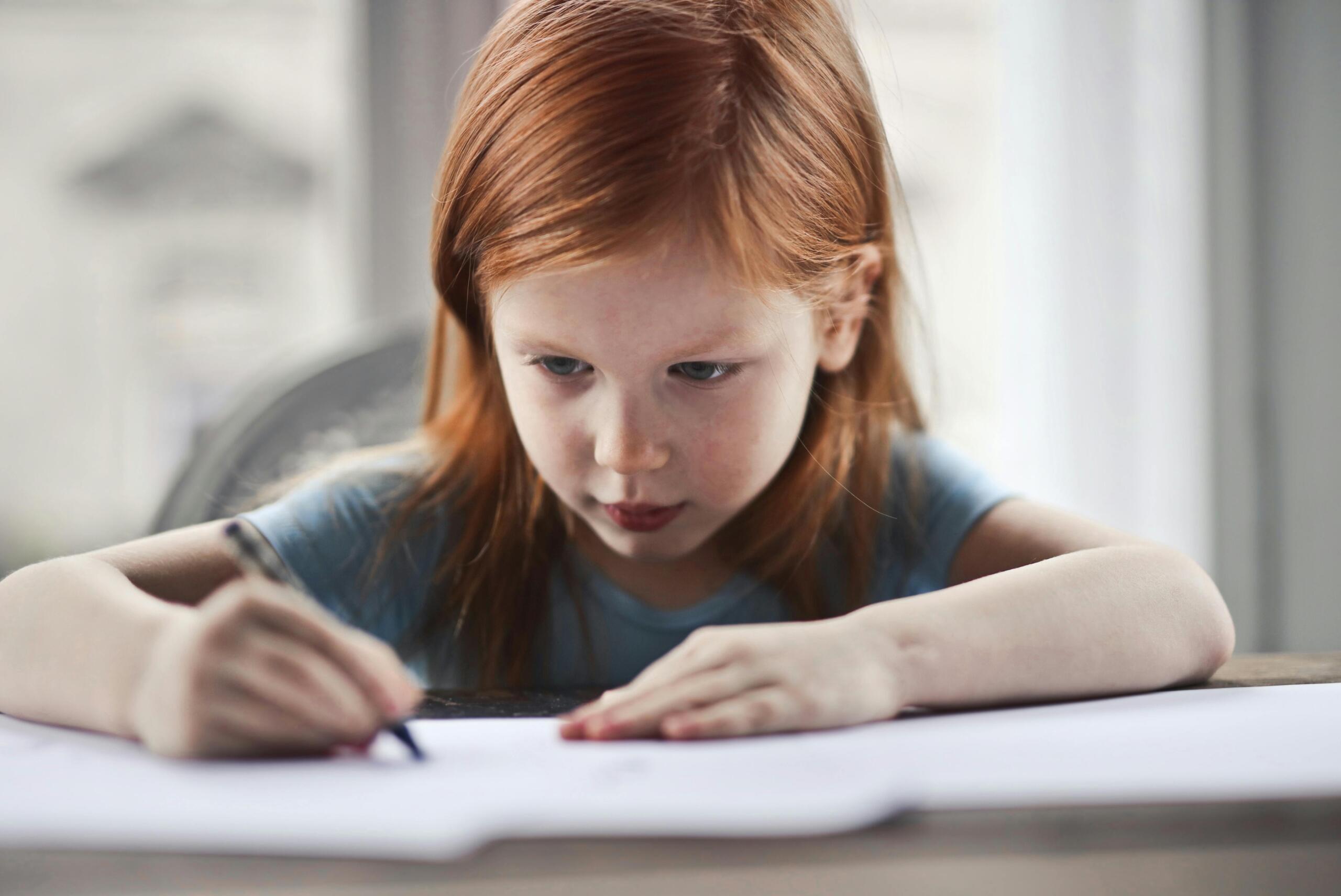 Girl writing on paper doing homework
