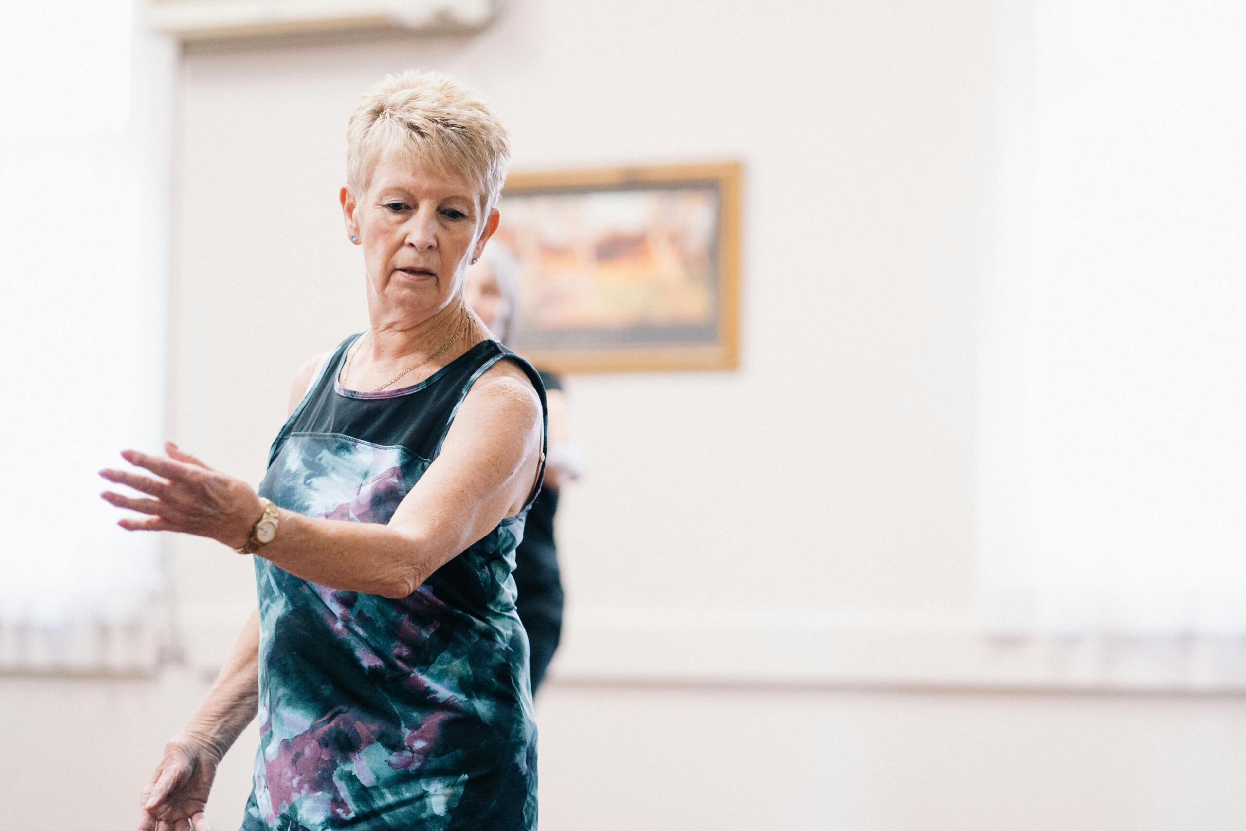 An elderly woman joyfully dancing with graceful movements.