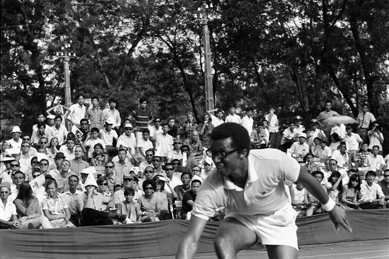 Arthur Ashe battles with his opponent as spectators watch