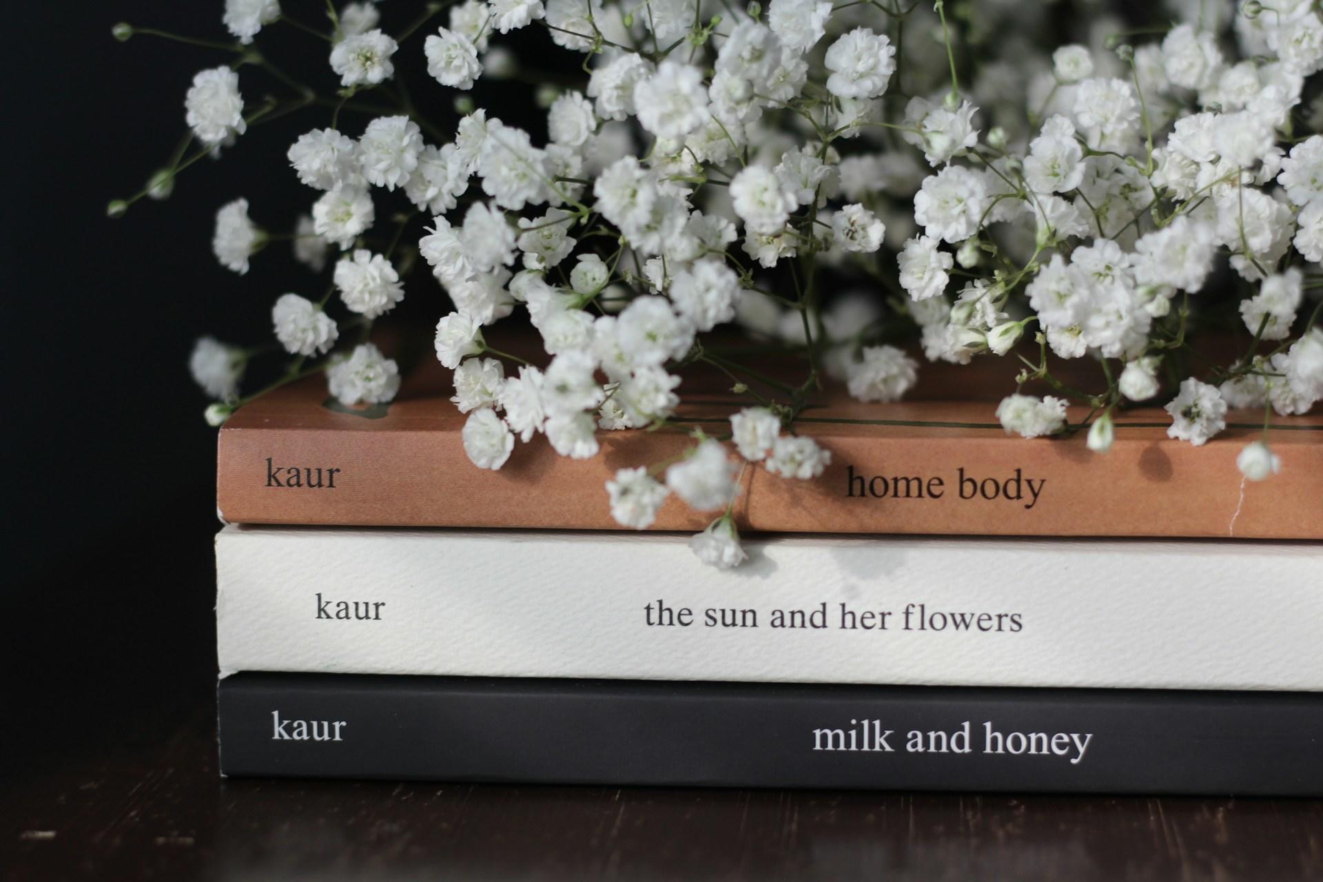 stack of rupi kaur books and flowers