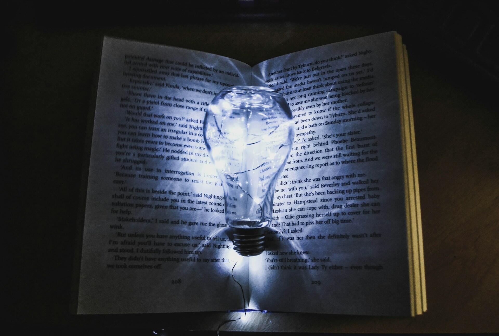 A lightbulb in front of a book.