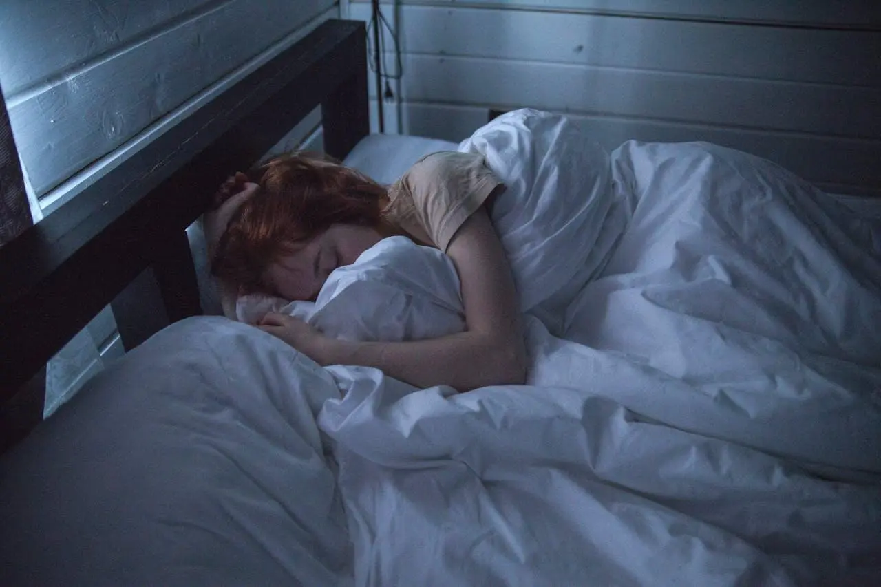 woman sleeping in a bed in a dark room