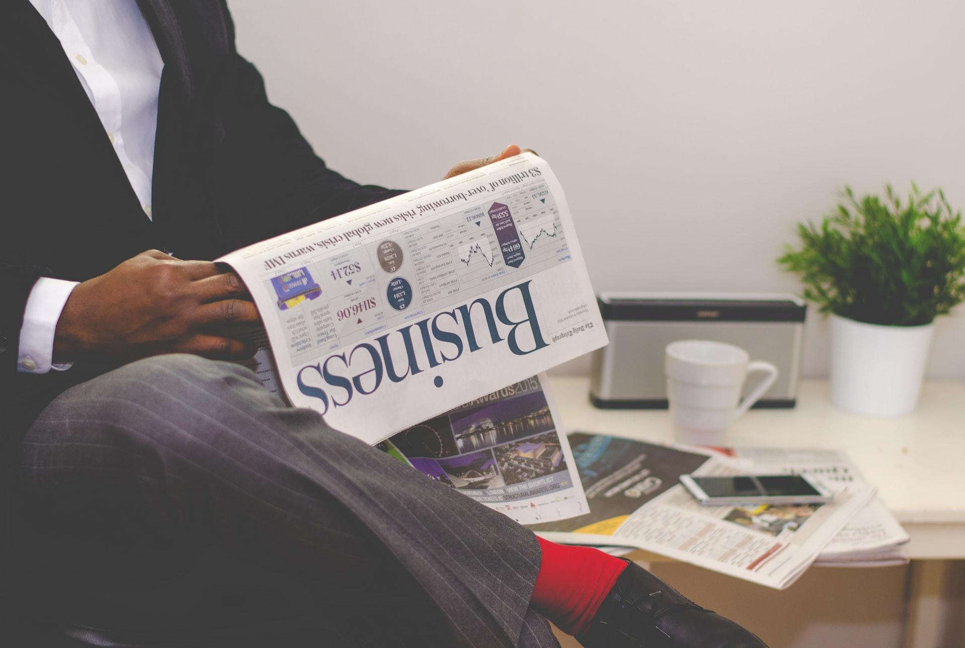 A man sitting and reading the business section of the newspaper
