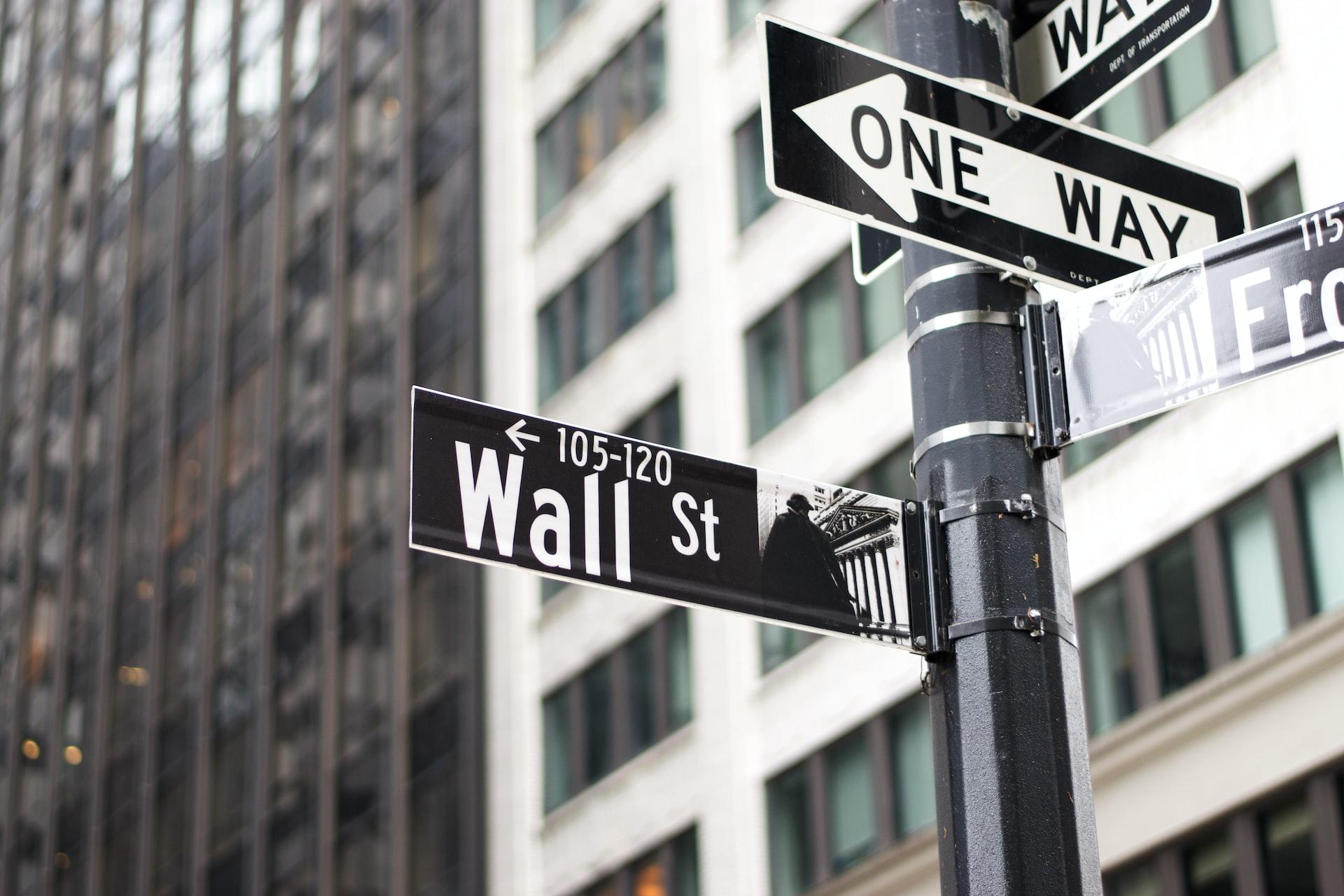 Street signs announcing Wall Street and one-way traffic.