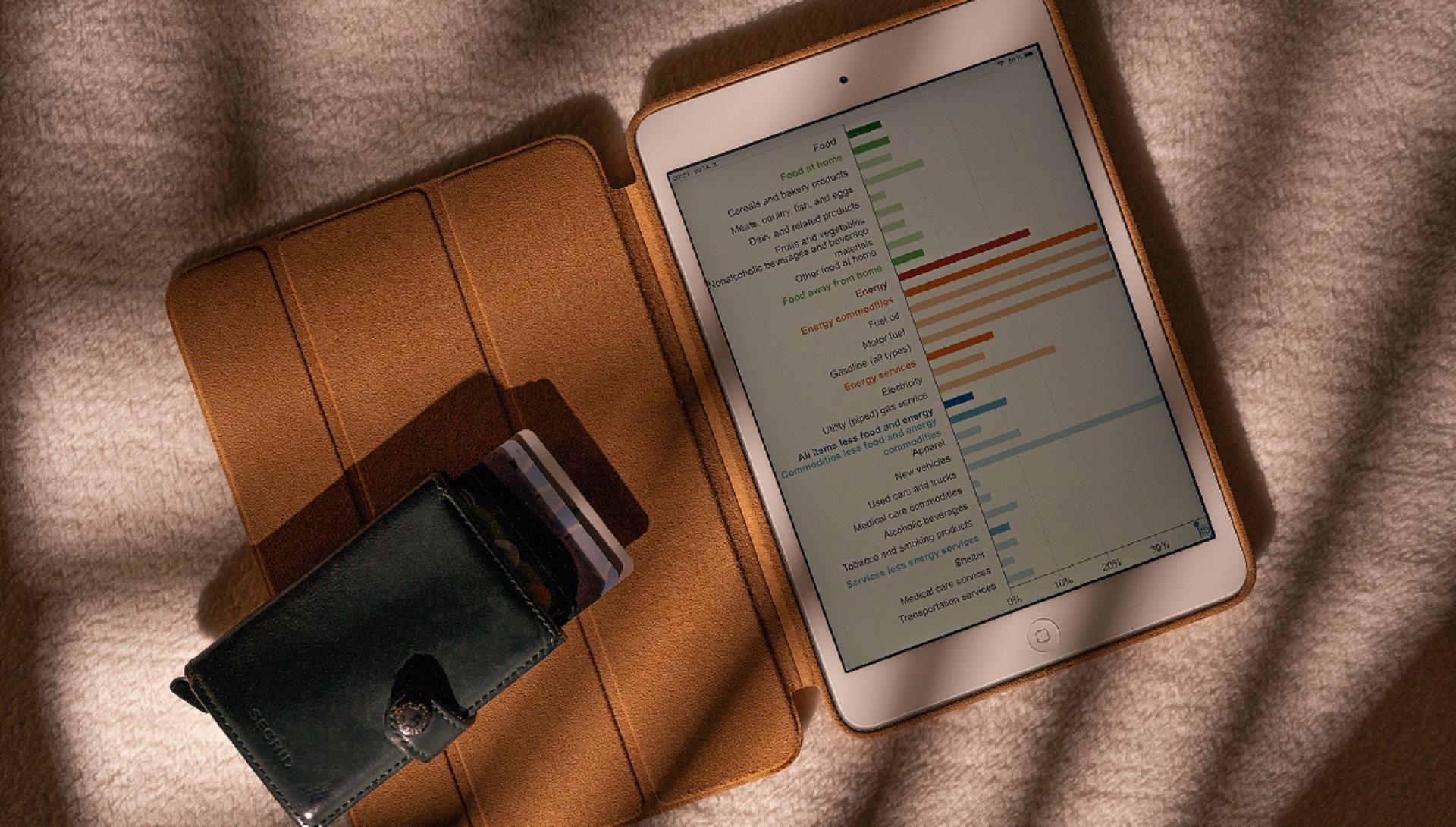 An open tablet showing a multi coloured bar graph listing household expenses