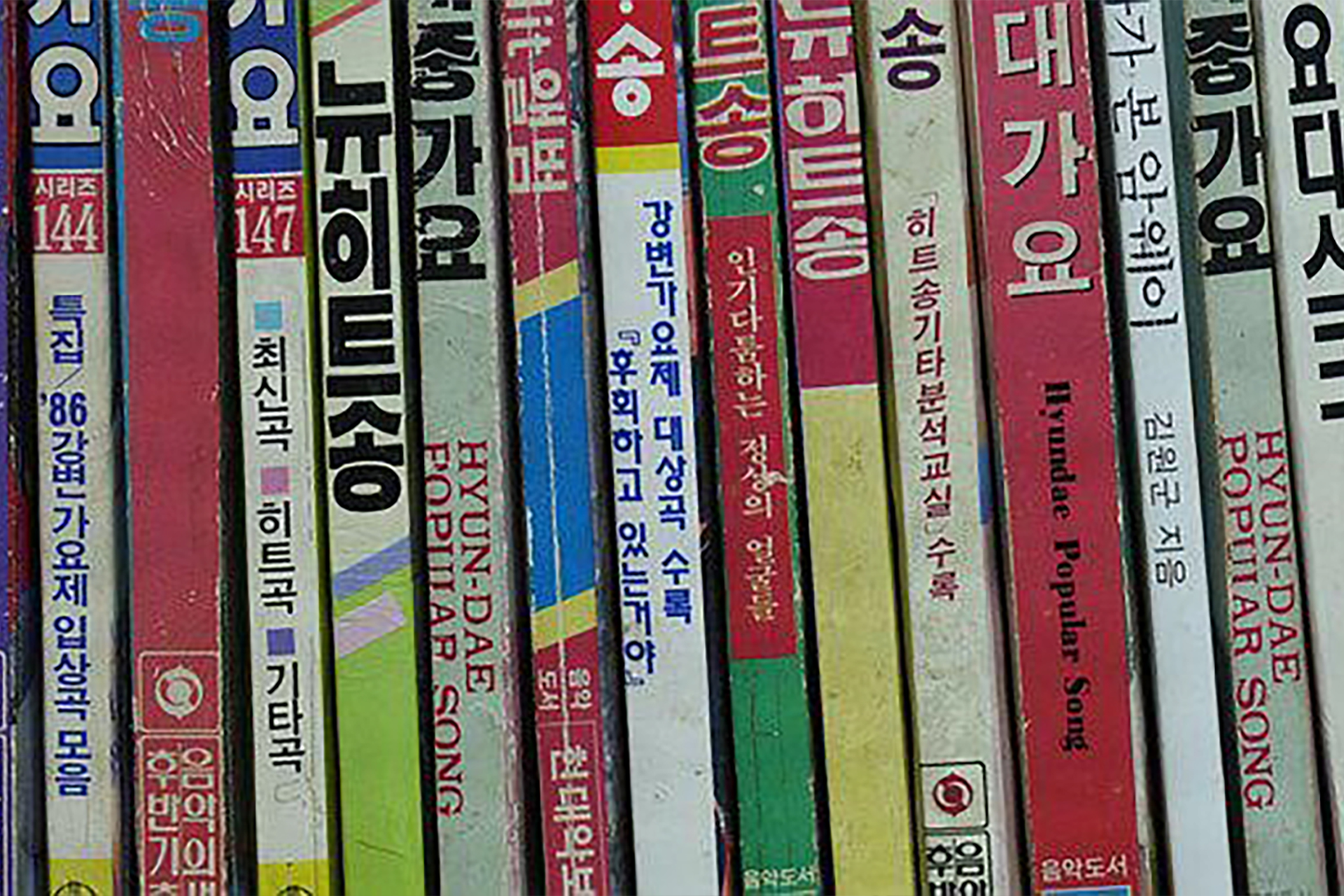 Several Korean Books lined up on a shelf.