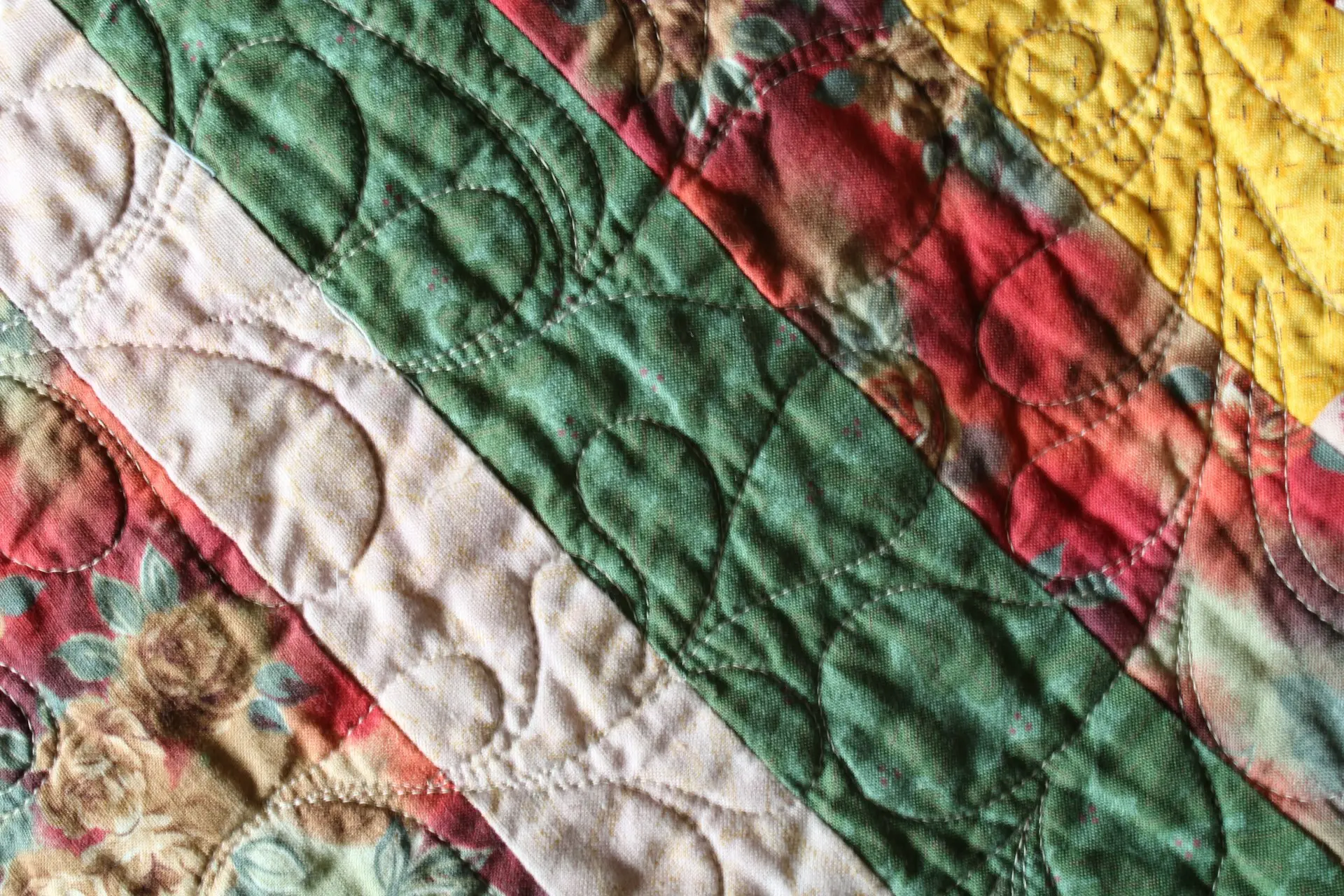a green, white, red and yellow multicoloured quilt