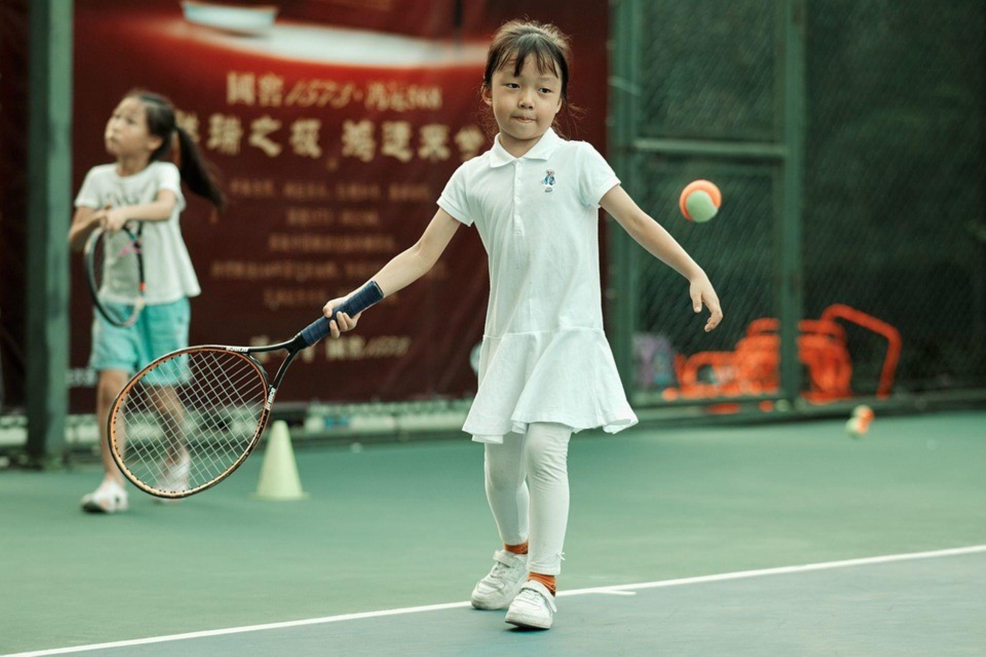 A young girl playing tennis